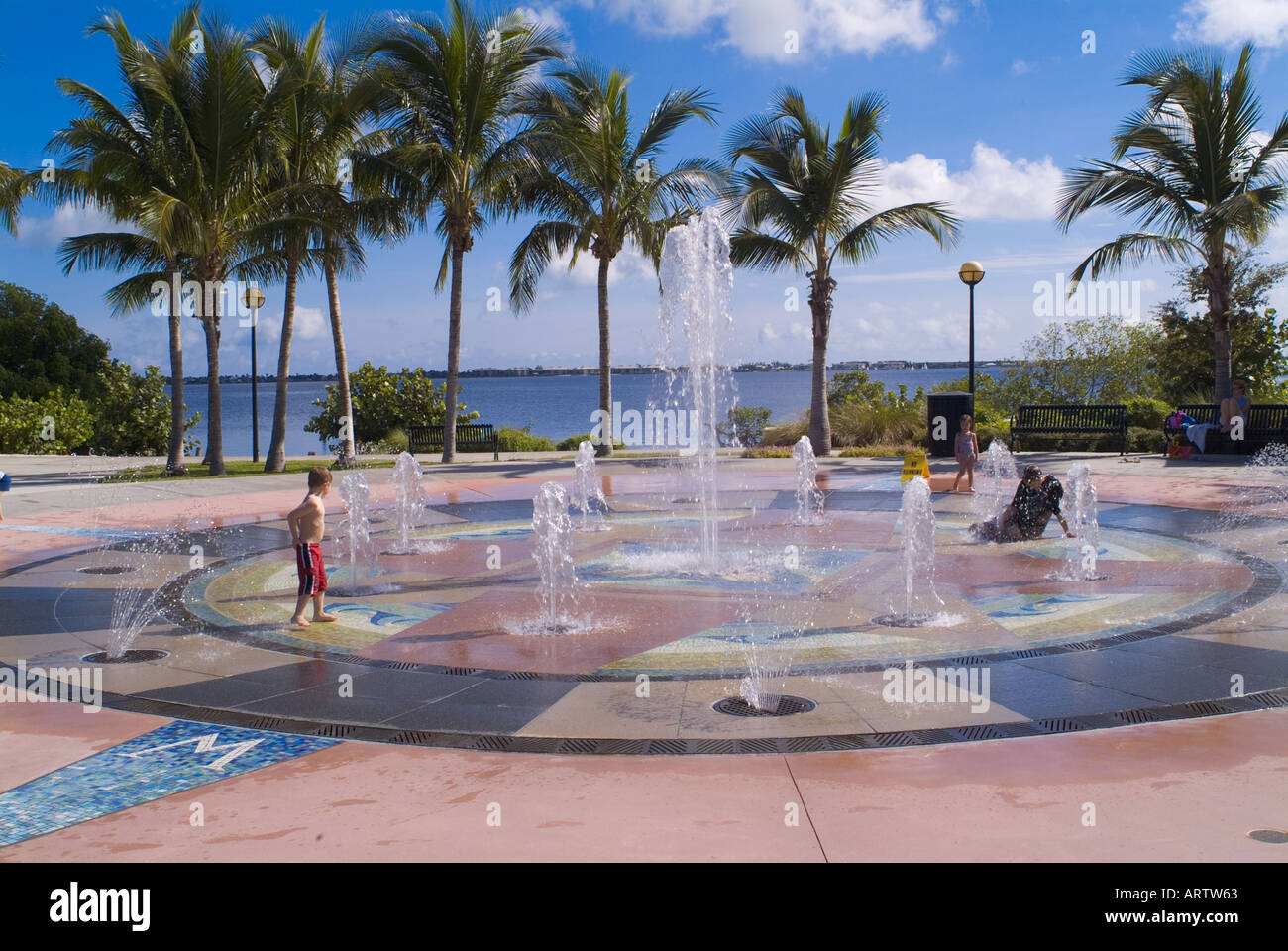 children playing in water fountain at a Florida park cooling off recreation fountains palm trees Stock Photo