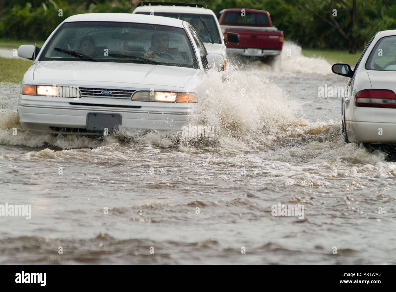 flooded road traffic cars in flood waters driving in flood conditions hazardous Stock Photo