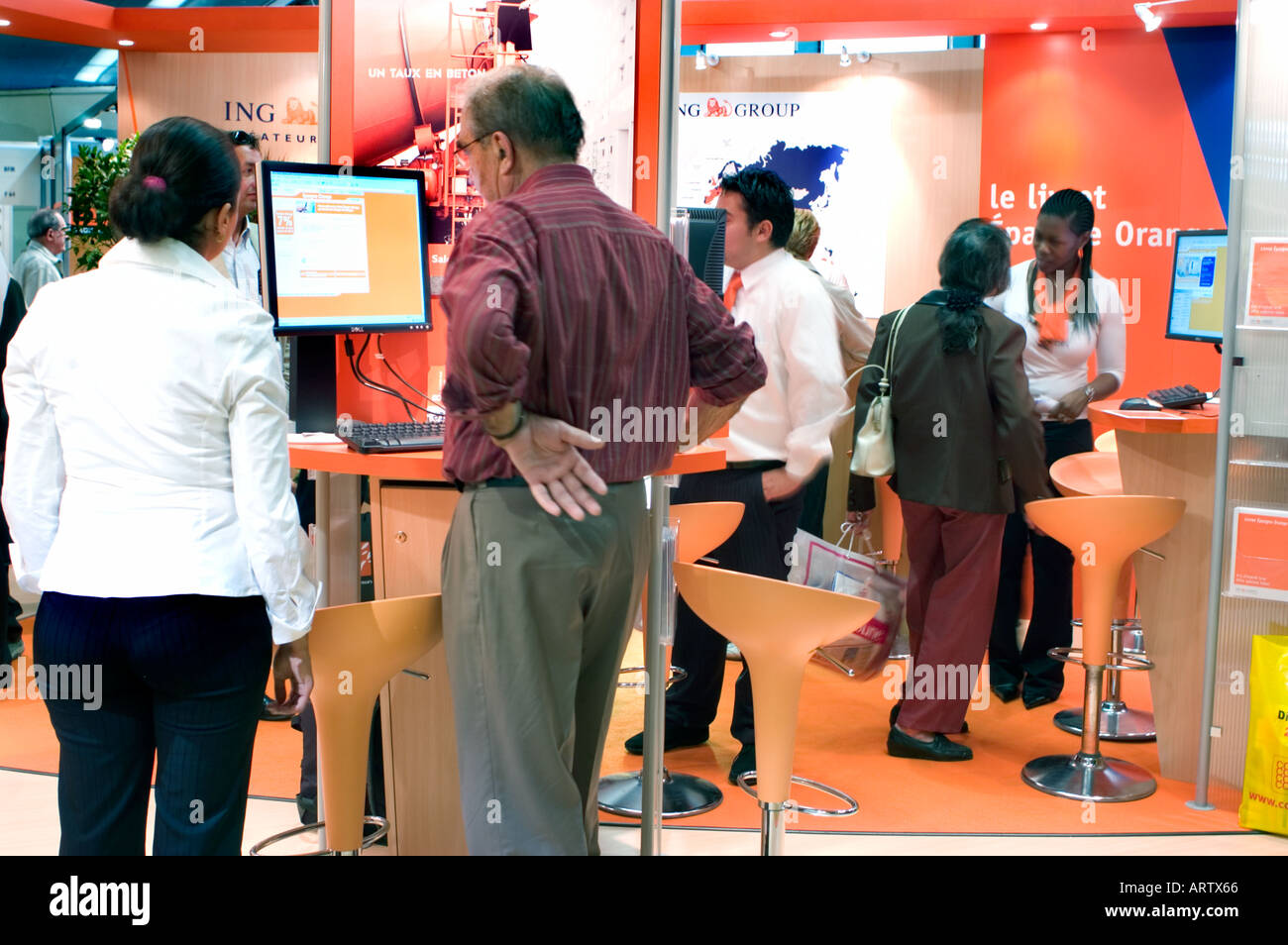 Man Meeting at Paris France Exhibit of 'ING' Internet Bank INVESTMENTS Online Banking with Female Sales, computer screen Stock Photo