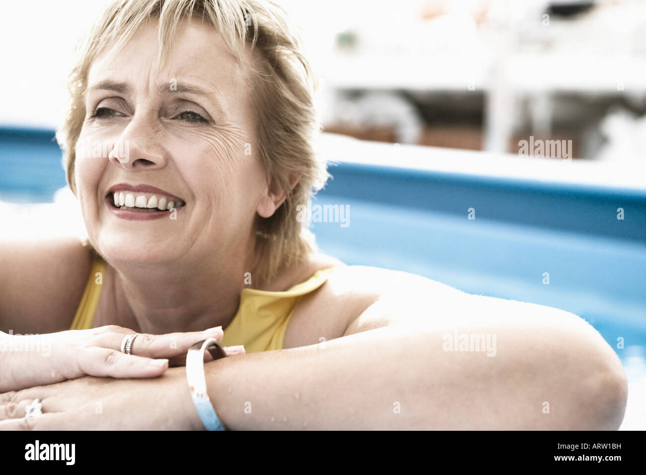 Woman leaning on edge of swimming pool hi-res stock photography and ...
