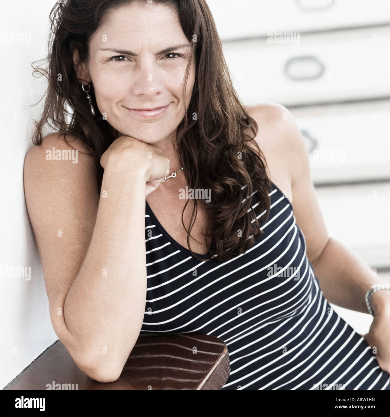 Portrait of a mid adult woman smirking with her hand on her chin Stock Photo