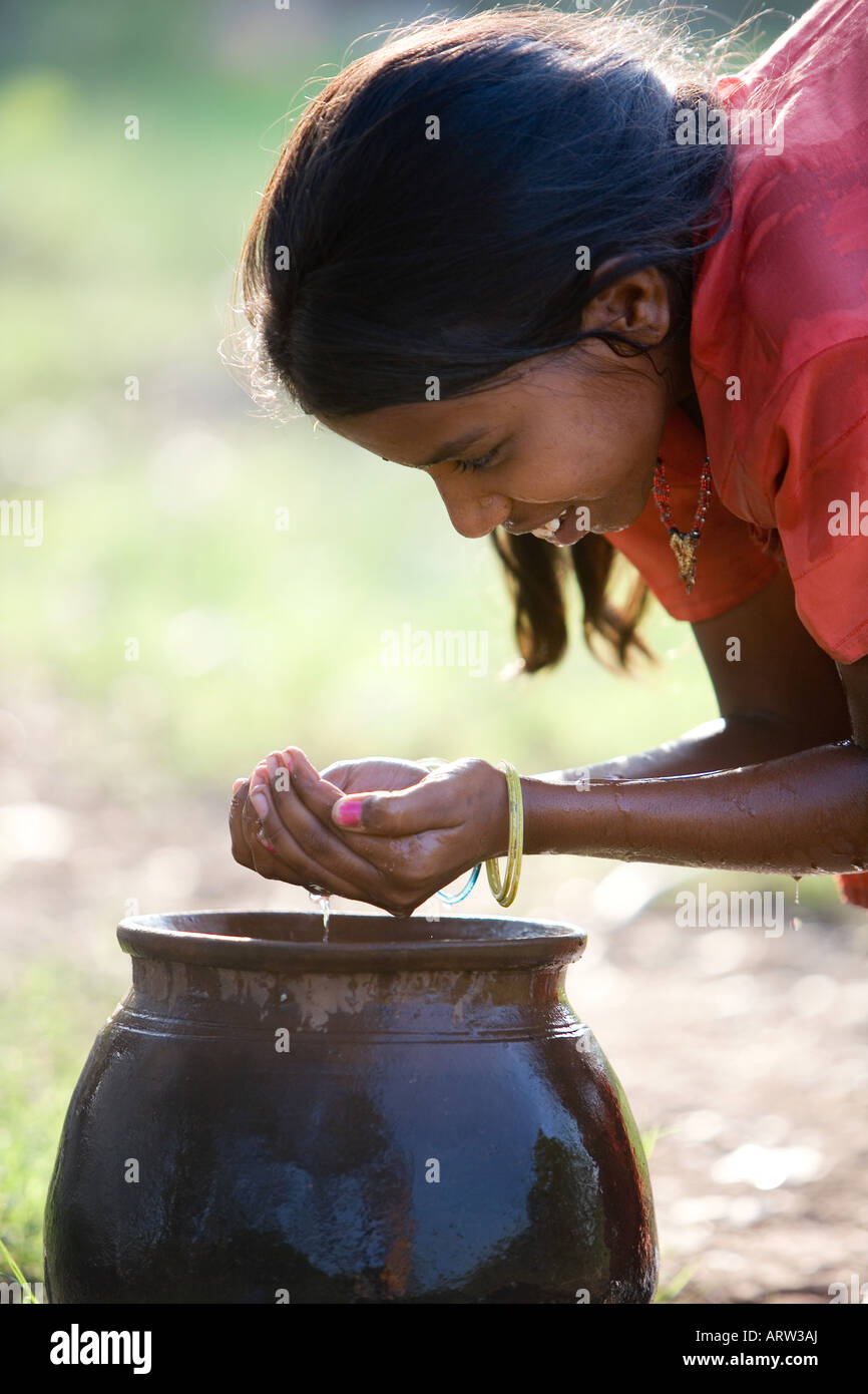 Indian girl drinking water from a clay pot in the countryside. Andhra