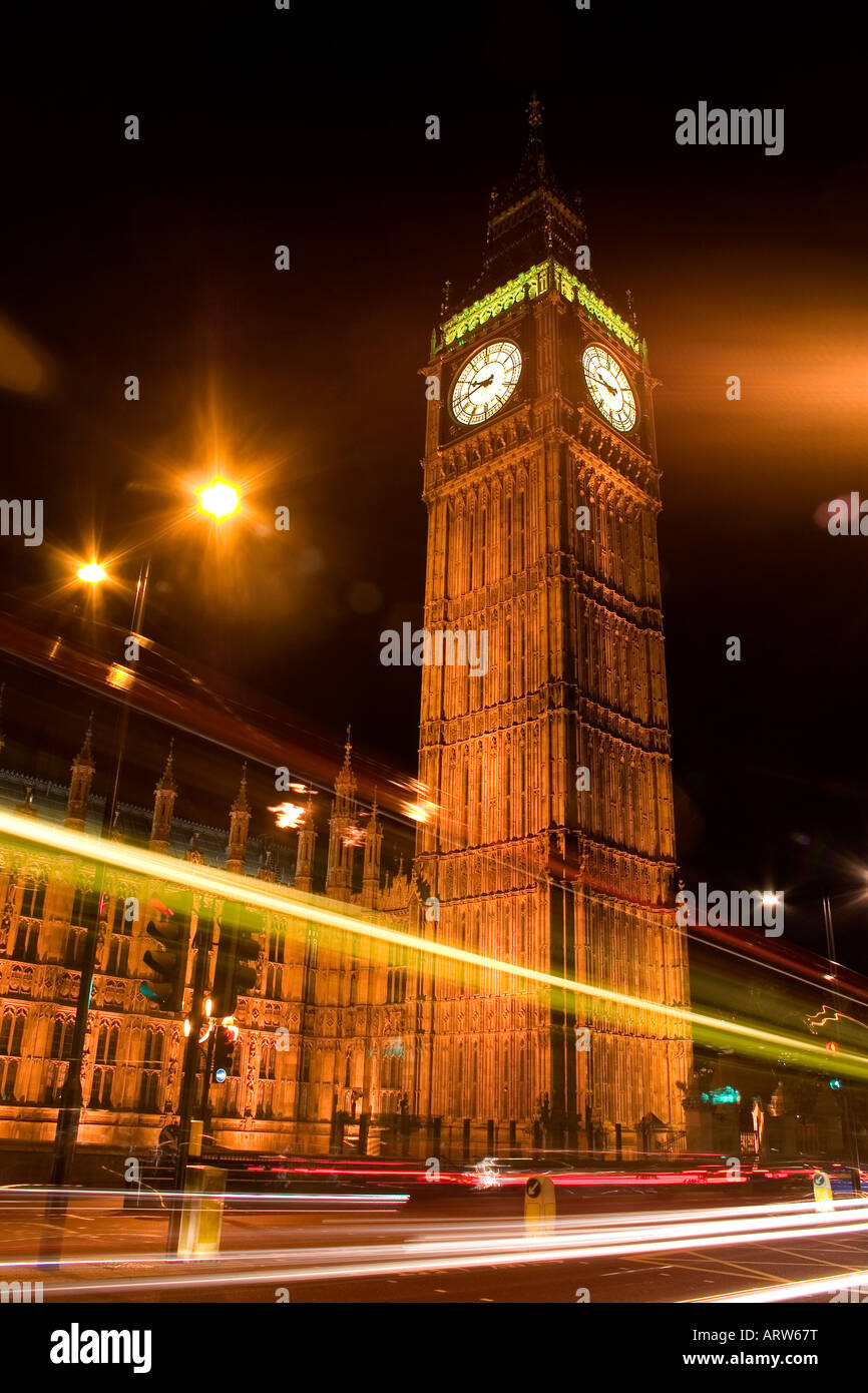 Night time traffic passes the clock tower (housing Big Ben) at the Houses of Parlianment, Westminster, London, UK Stock Photo
