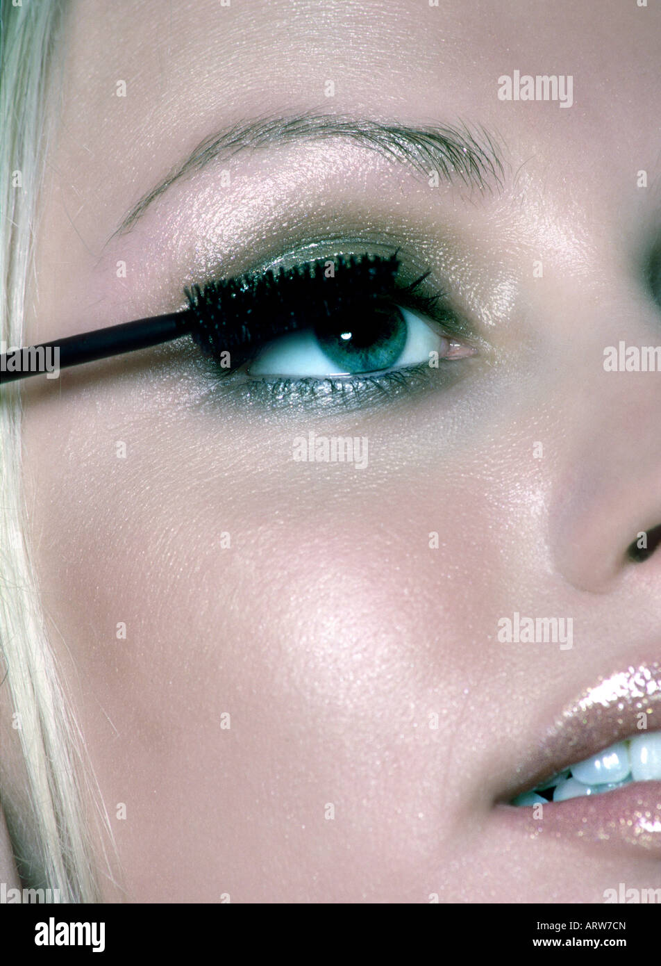 Woman applying mascara on her eyelashes Stock Photo