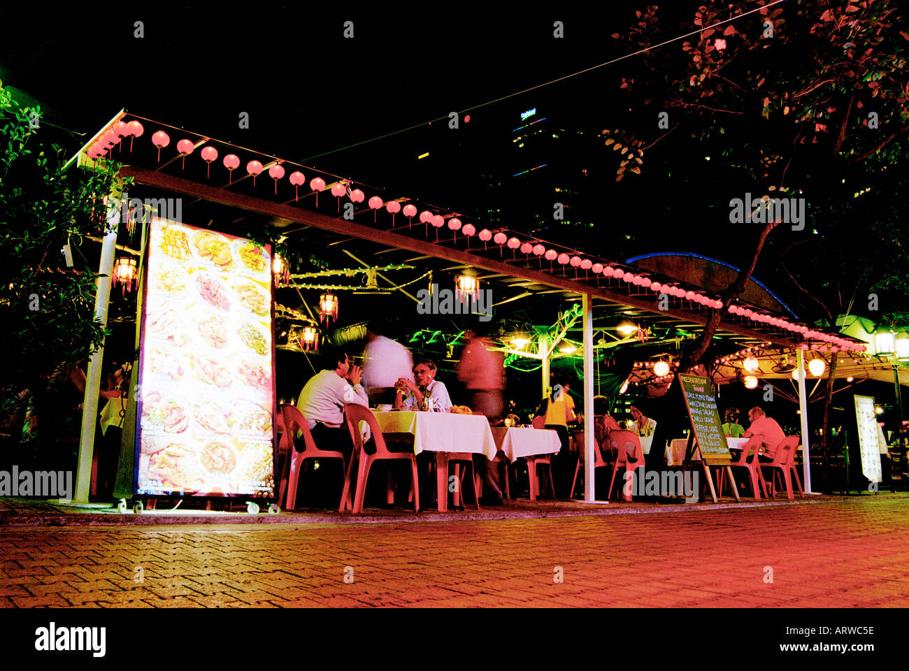 People dining at a restaurant on Boat Quay by the river in Singapore