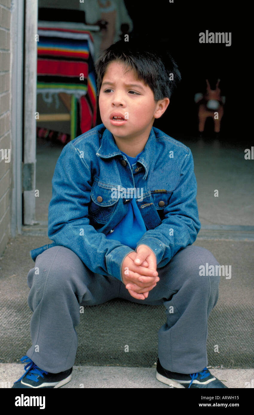 7 year old Latino boy sitting on steps at Cinco de Mayo Festival . St Paul Minnesota USA Stock Photo