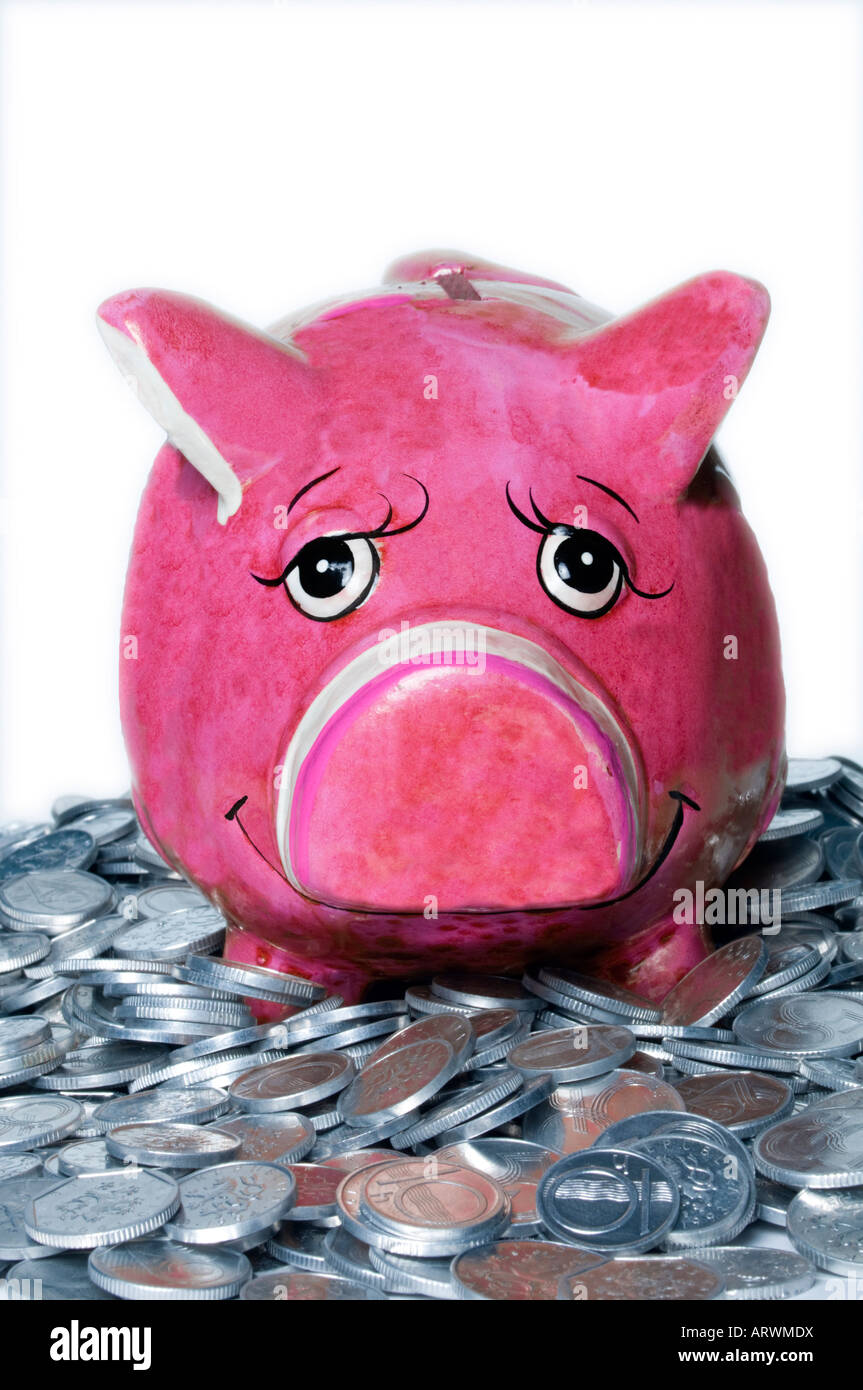 Smiling Piggy Bank sitting in coins Stock Photo