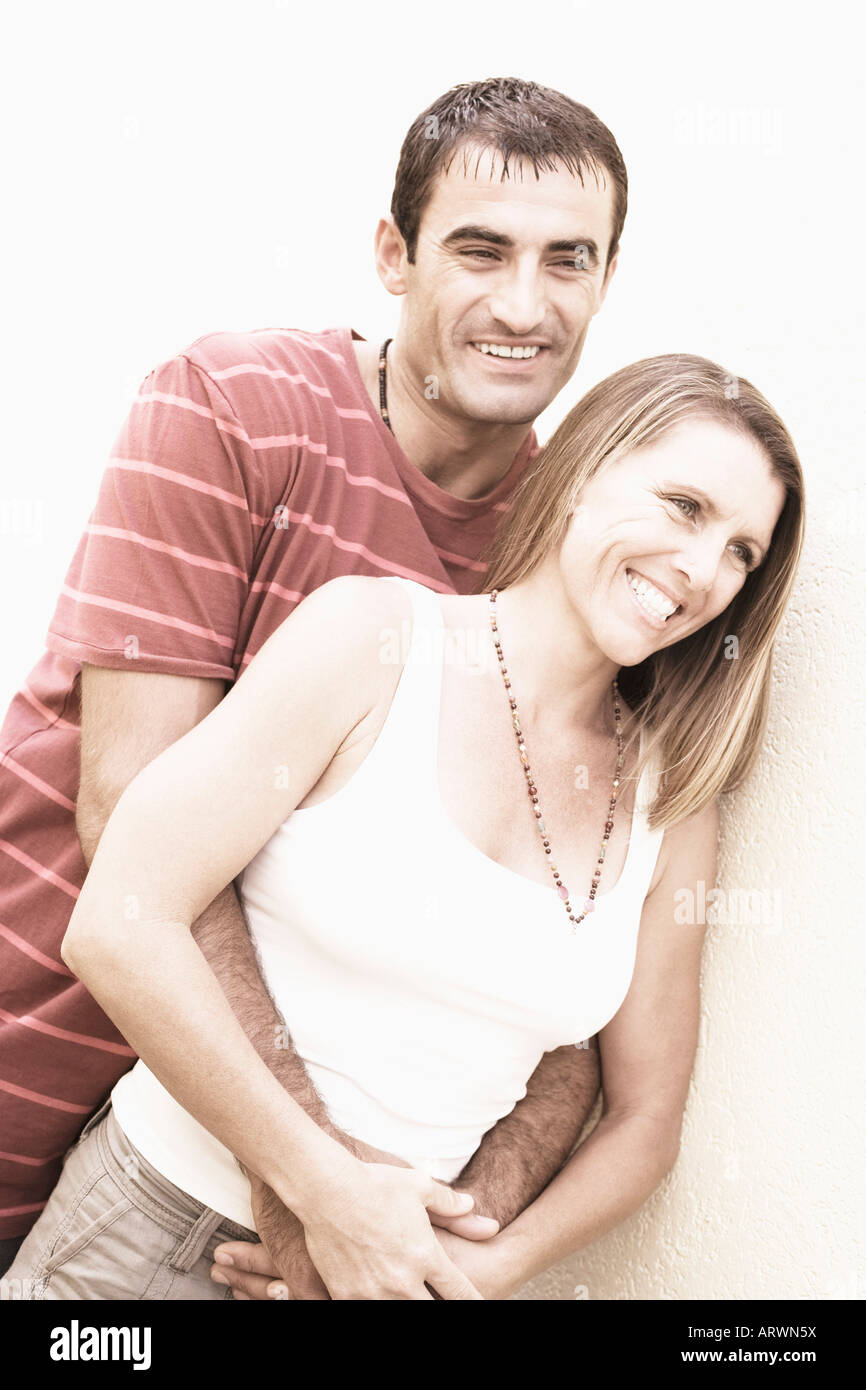 Mid adult man embracing a mid adult woman from behind and smiling Stock ...