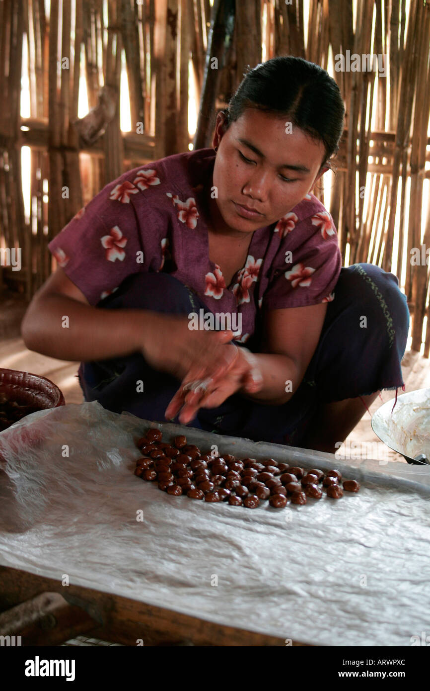 Burmese woman making confectionery from palm sugar between Bagan and