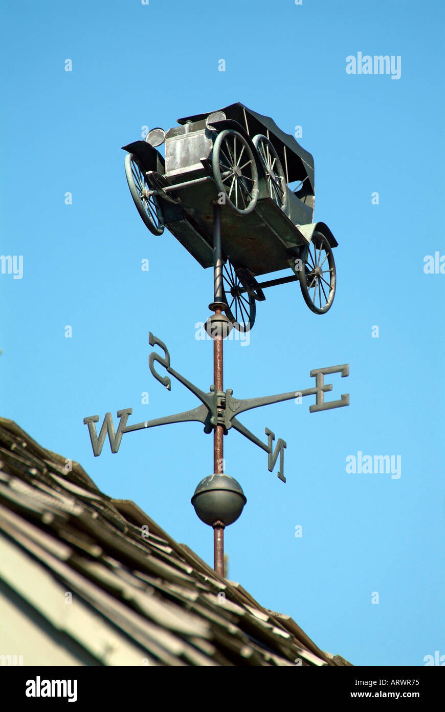 Weather vane in the shape of an antique automobile car shows the