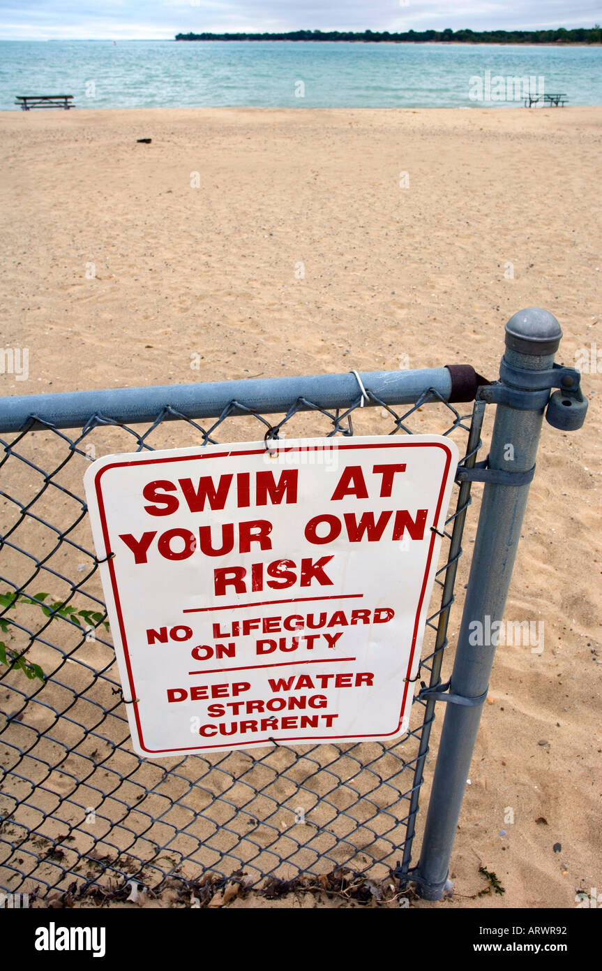 Sign on Lake Huron warns bathers to swim at your own risk no lifeguard on duty Stock Photo