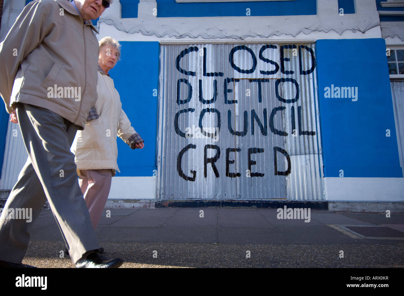 A business daubs a message 'closed due to council greed' on the shutters blaming increased business rates for its closure. Stock Photo