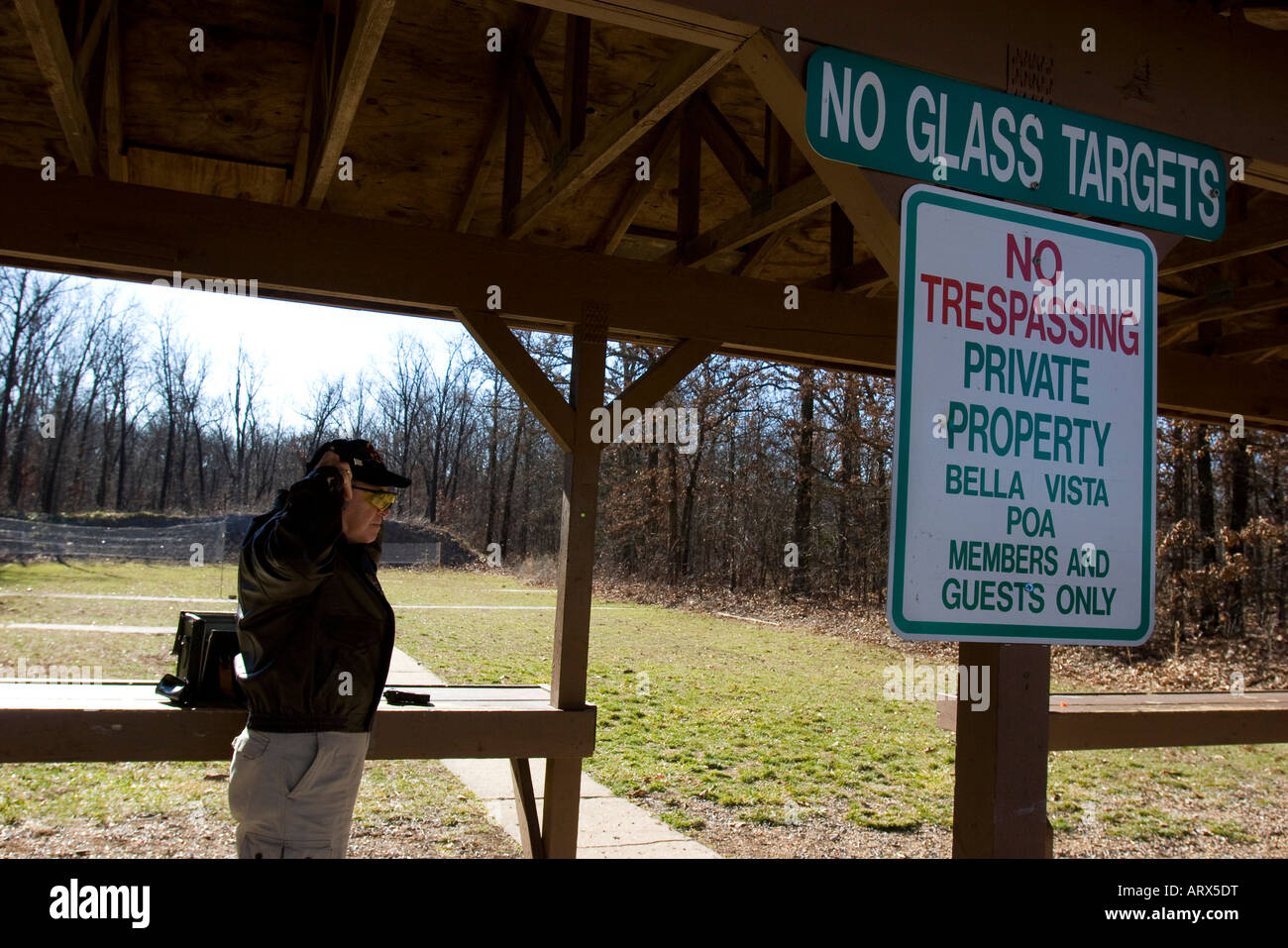 A gun enthusiast puts on his ear protection before target shooting at