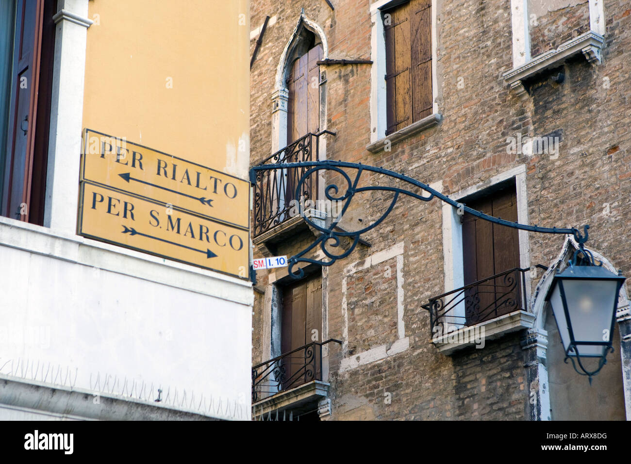 Signs pointing the way to Per Rialto or Per S Marco to San Marco across the labyrinth of streets and canals in Venice, Italy Stock Photo