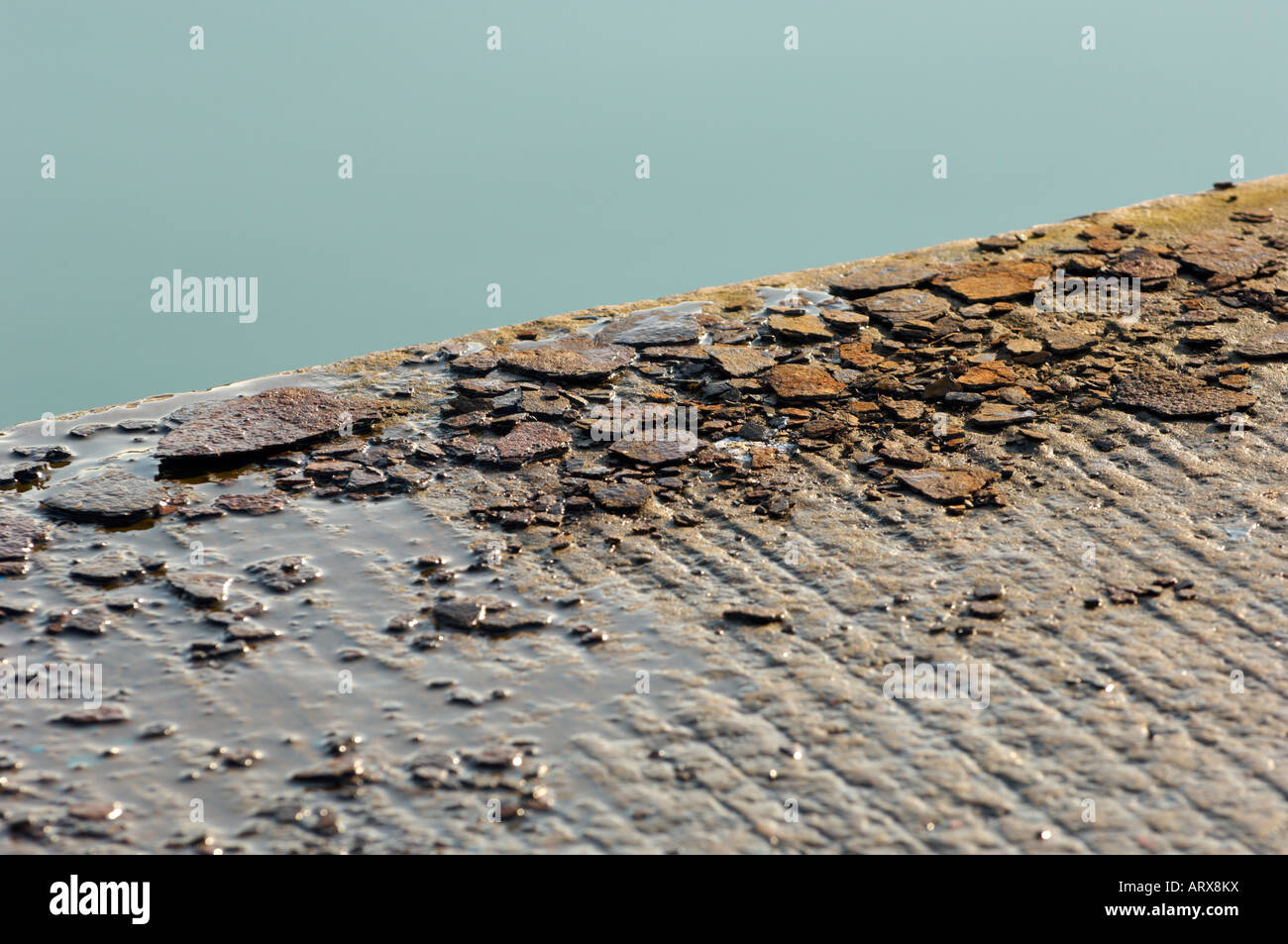 Flakes of rust sitting on a quayside Stock Photo - Alamy