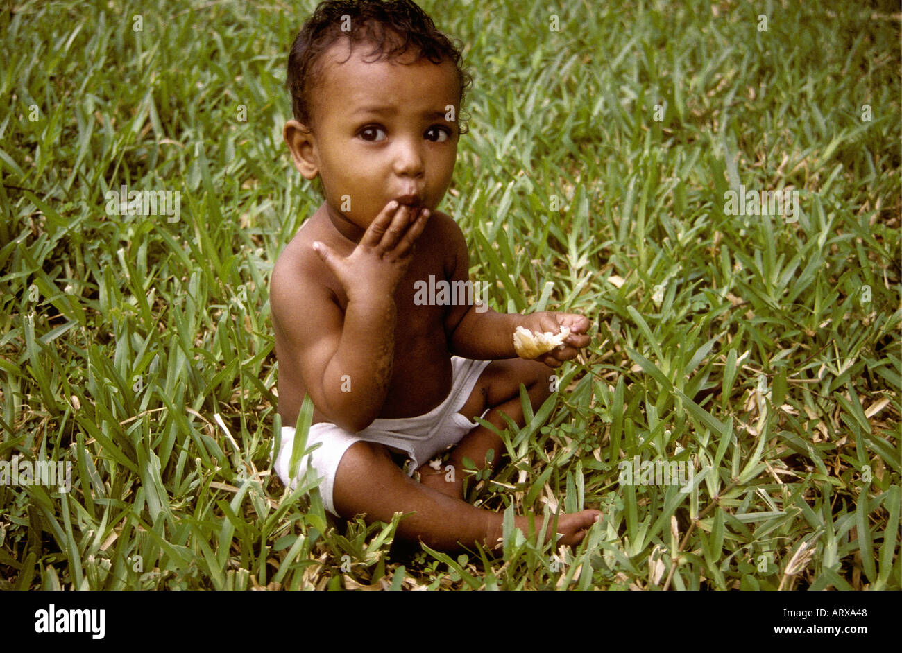 Small boy about one year old eating a piece of bread Zanzibar Tanzania East Africa Stock Photo