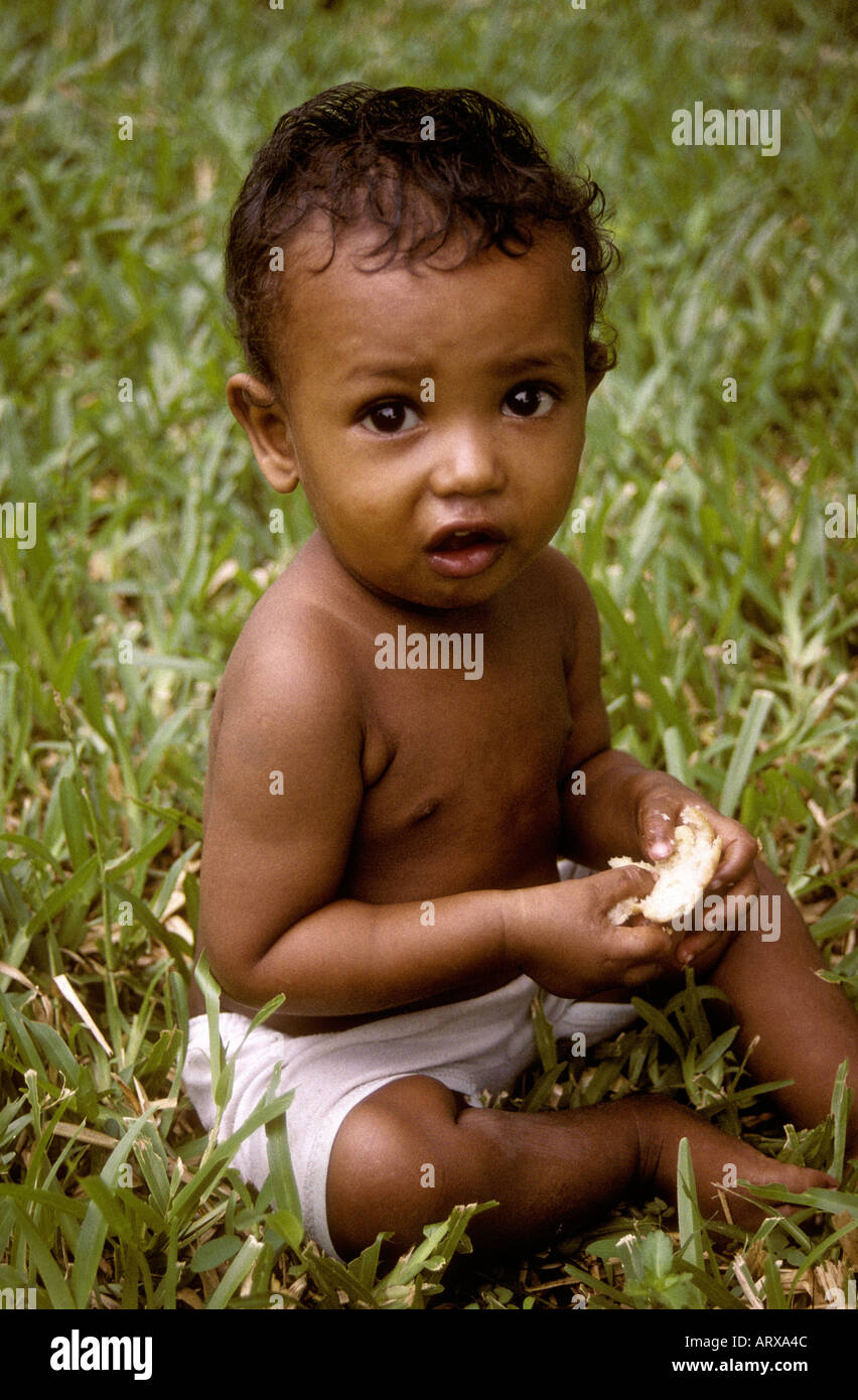Small boy about one year old eating a piece of bread Zanzibar Tanzania East Africa Stock Photo