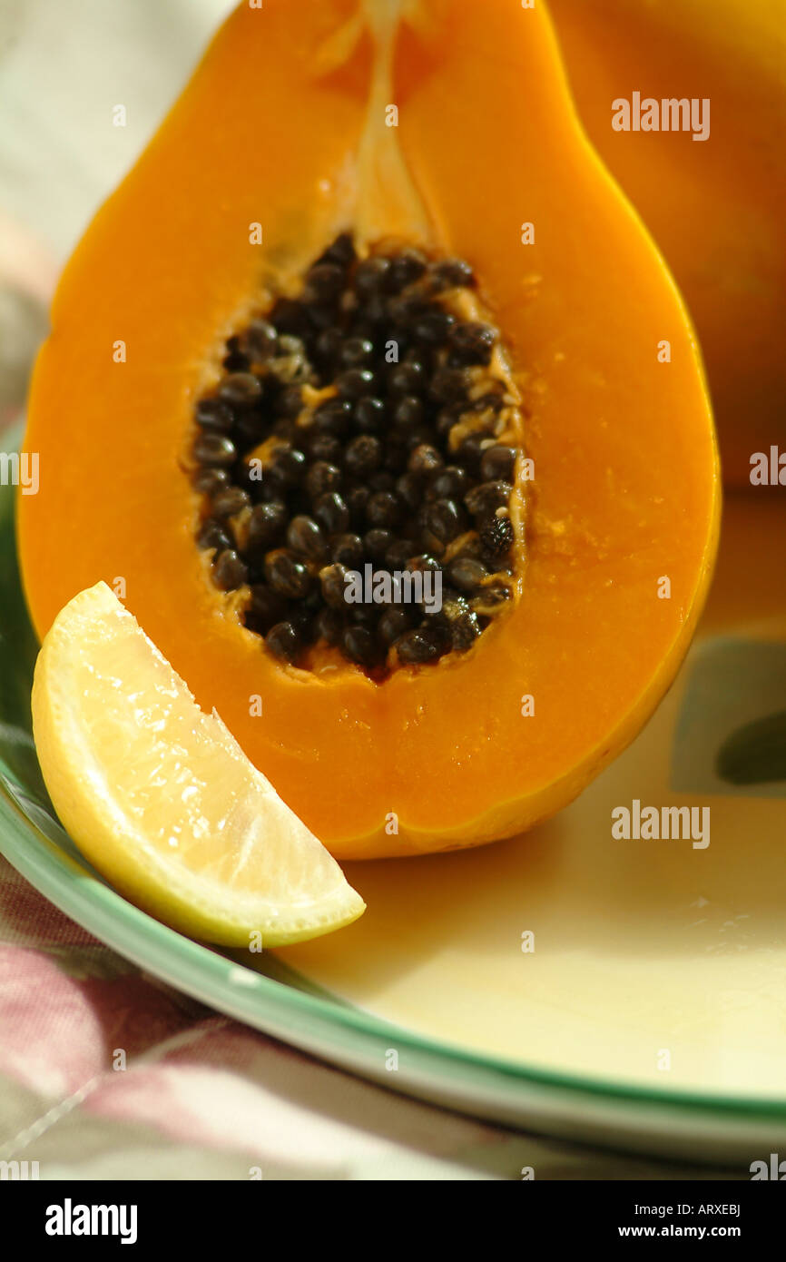 Plate of ripe papaya fruit with lemon wedge Stock Photo