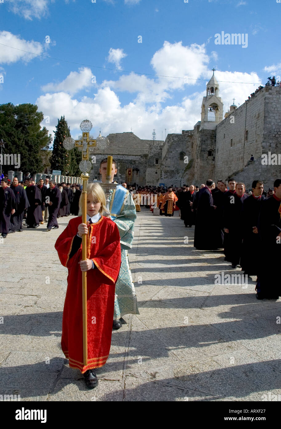 Palestinian Authority Bethlehem church of the Nativity Orthodox Xmas Procession outside the the church 2 boys leading the procession vertical Stock Photo