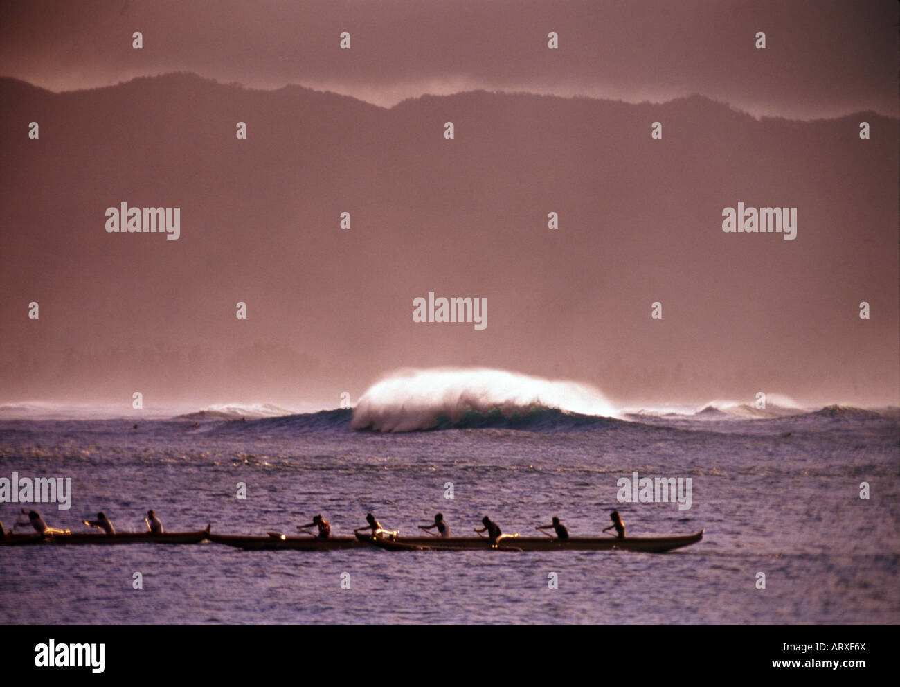 A canoe clug paddles into the shore at Haleiwa on the north shore of Oahu Stock Photo