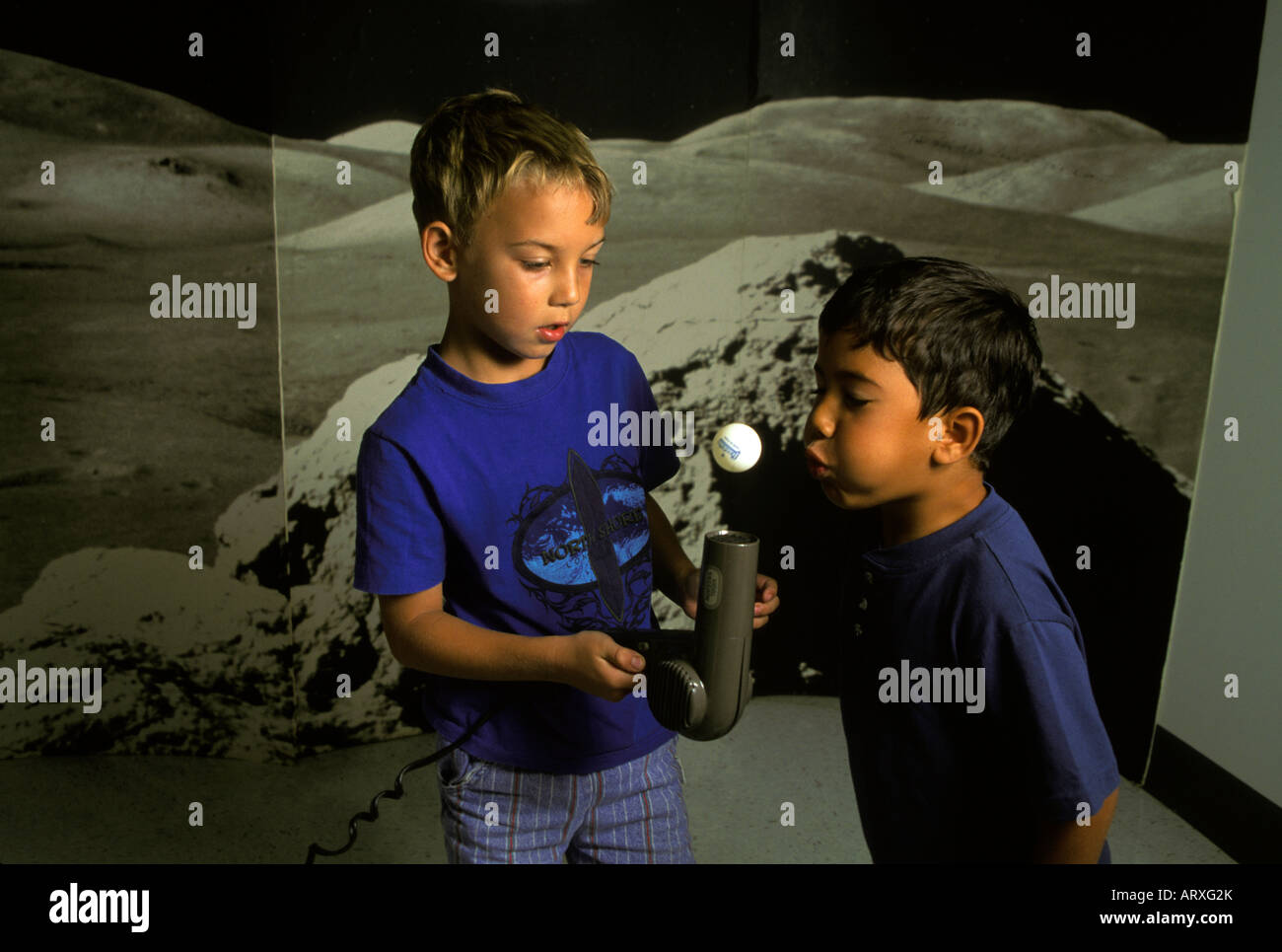 2 children experiment with concept of anti-gravity using ping-pong ball &  hair dryer. Moonscape background at science center Stock Photo - Alamy