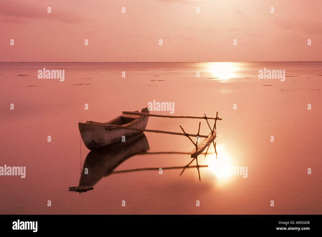 Outrigger canoe in Aitutaki lagoon at night under full moon Stock Photo