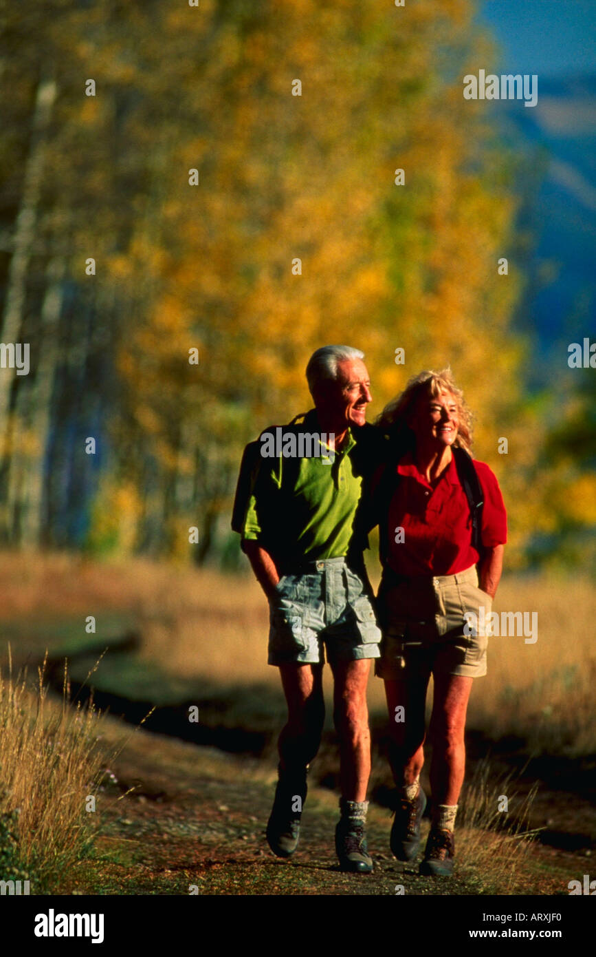 Senior couple walking down road in autumn colors Stock Photo