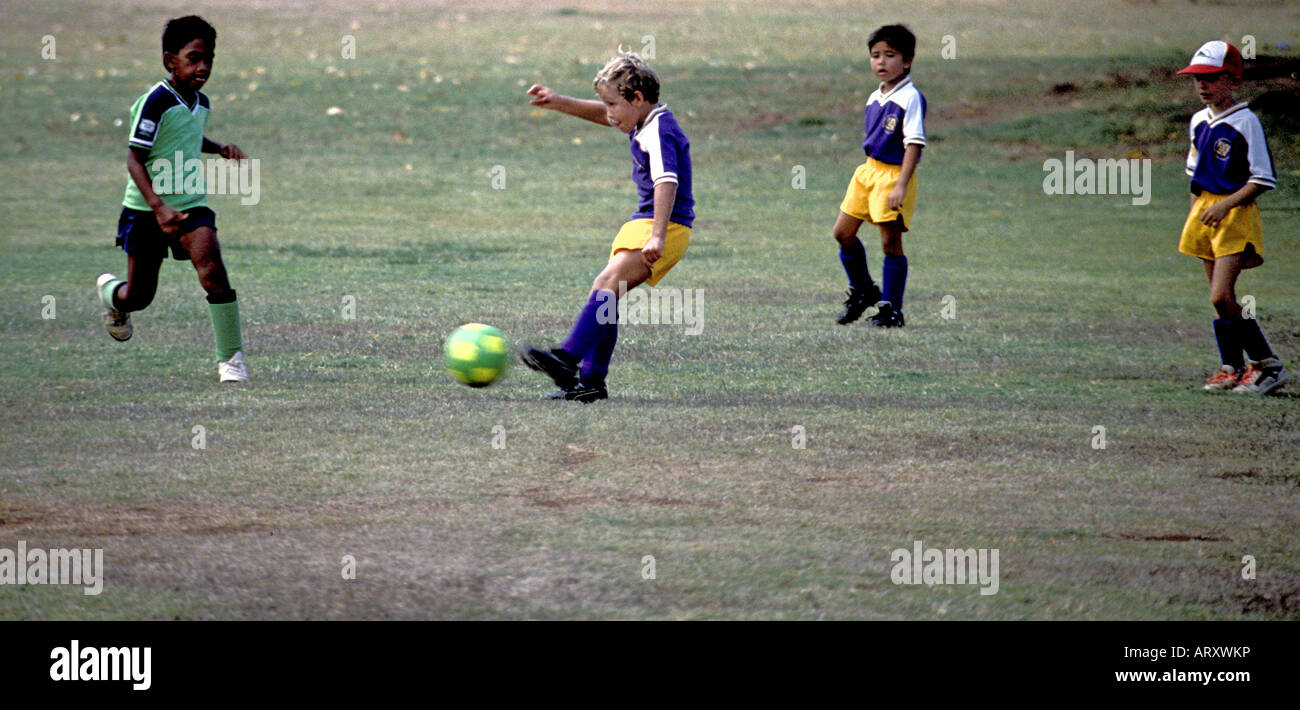 Four children playing team soccer, Island of Oahu Stock Photo Alamy