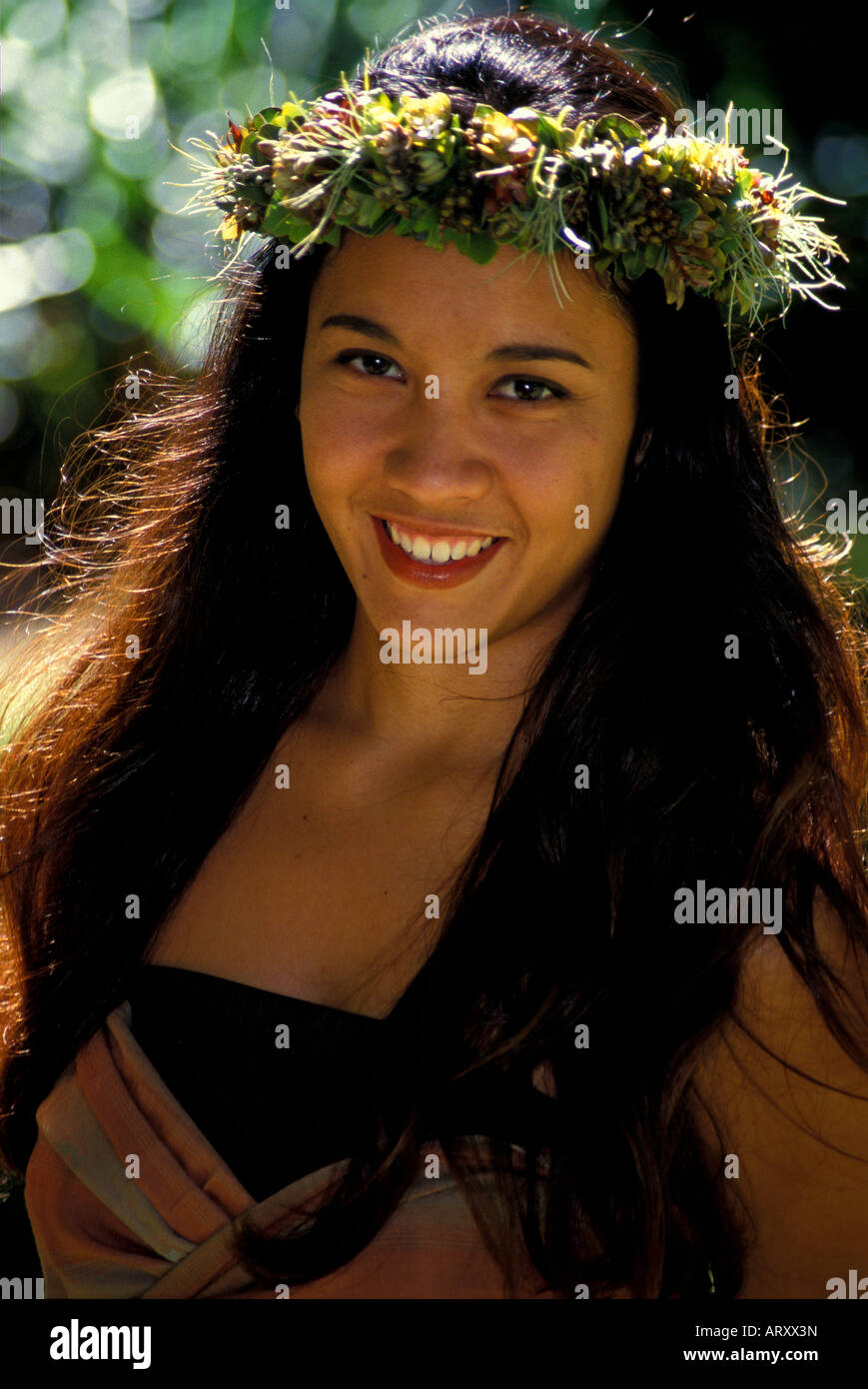 Young smiling Hawaiian hula dancer in a park in Honolulu on Oahu Stock Photo