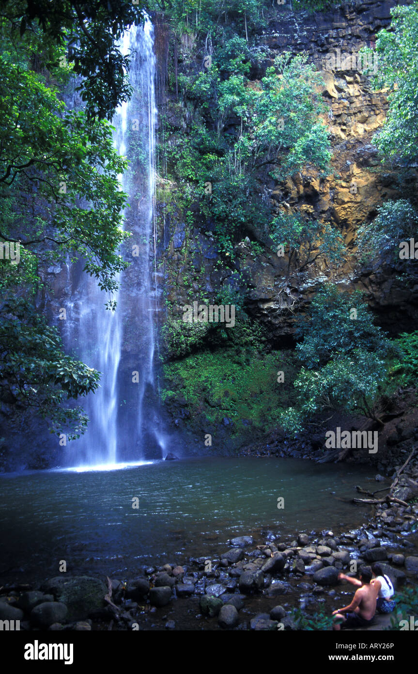 Couple admires Secret Falls, reached by kayaking up Wailua River to trailhead and then hiking to falls. Stock Photo