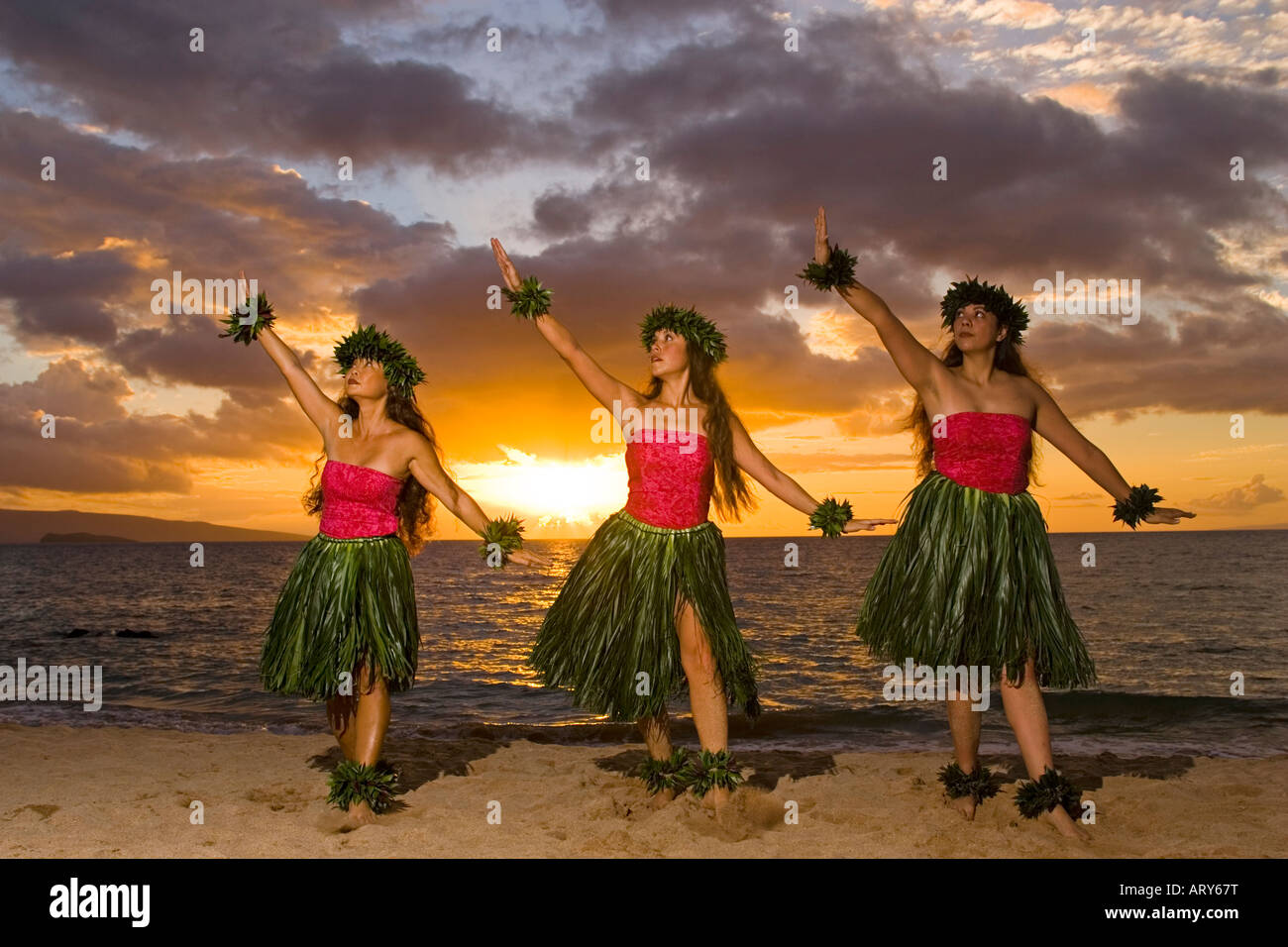 Three hula dancers in ti leaf skirts dance on the beach at sunset at  Makena, Maui Stock Photo - Alamy