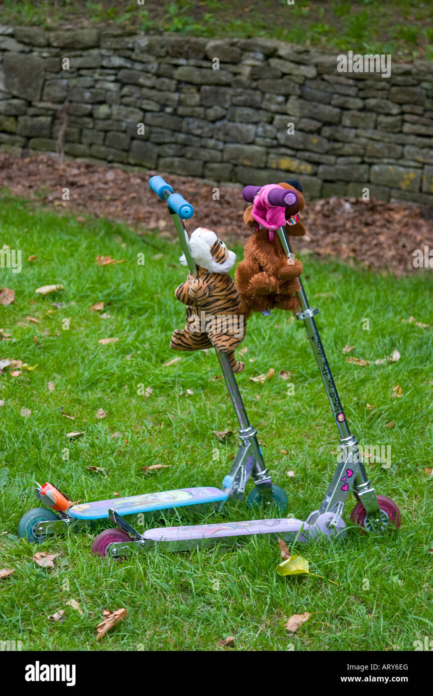 Pair of child's toy scooters with cuddly toys Stock Photo