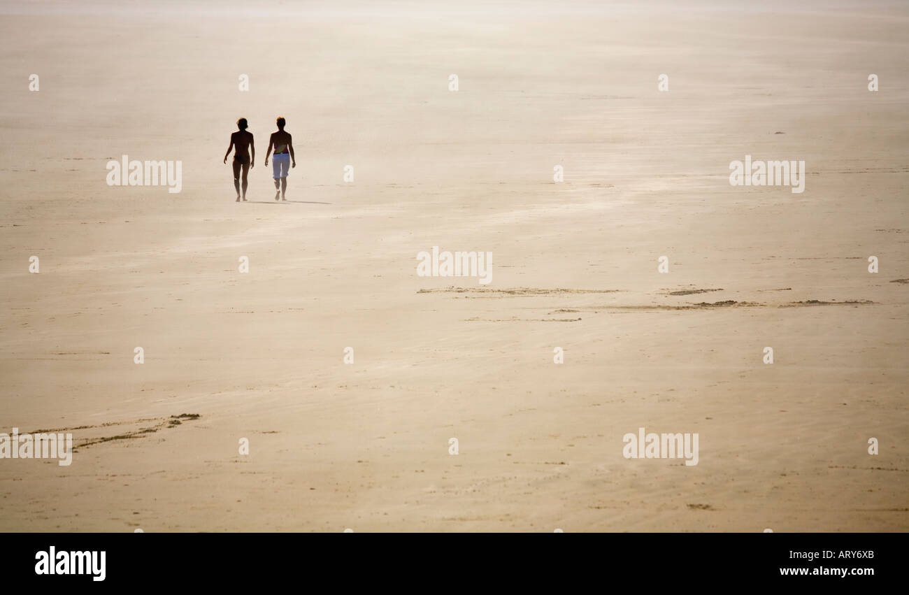 Two women walking on windswept empty beach Long Beach Pacific Rim national park reserve Vancouver island Canada Stock Photo