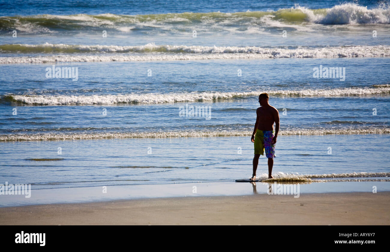 Man with skimboard Long Beach Pacific Rim national park reserve Vancouver island Canada Stock Photo
