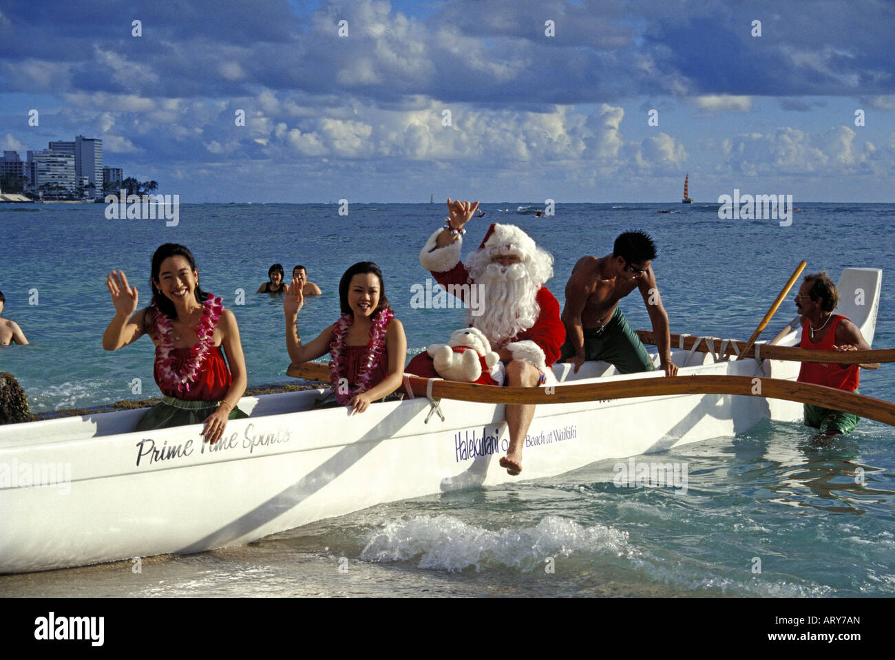 Santa arrives by outrigger canoe on Christmas Eve on Waikiki Beach with
