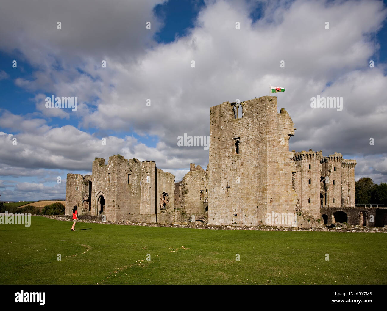 Woman looking at Raglan Castle from the south bowling lawn Raglan Castle Monmouthshire Wales UK Stock Photo