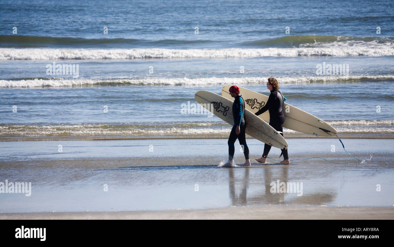 Surfers walking on Long Beach Pacific Rim national park reserve Vancouver island Canada Stock Photo