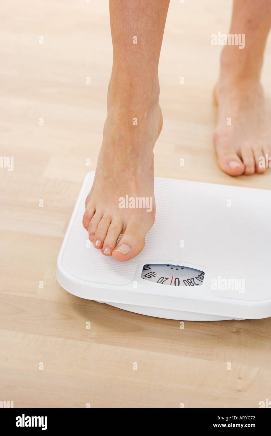 Feet stepping onto bathroom scale Stock Photo Alamy