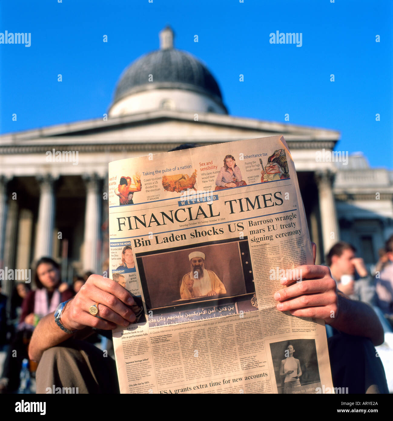 Man reading Osama Bin Laden headline  'Bin Laden Shocks US'  in the Financial Times newspaper  London October 2004 Stock Photo