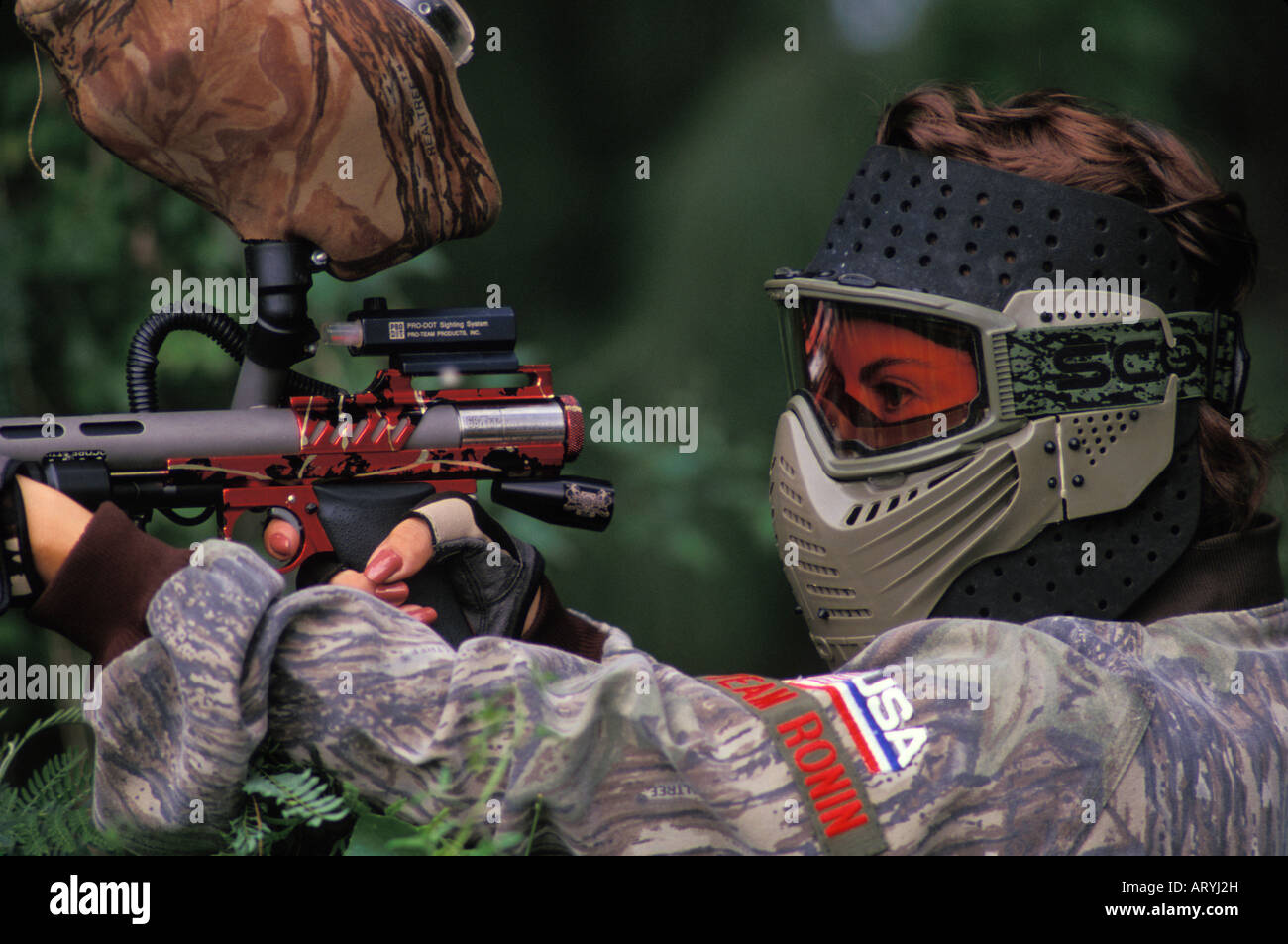 Woman engaged in paintball sport, a paramilitary leisure type game, Kualoa Ranch Stock Photo