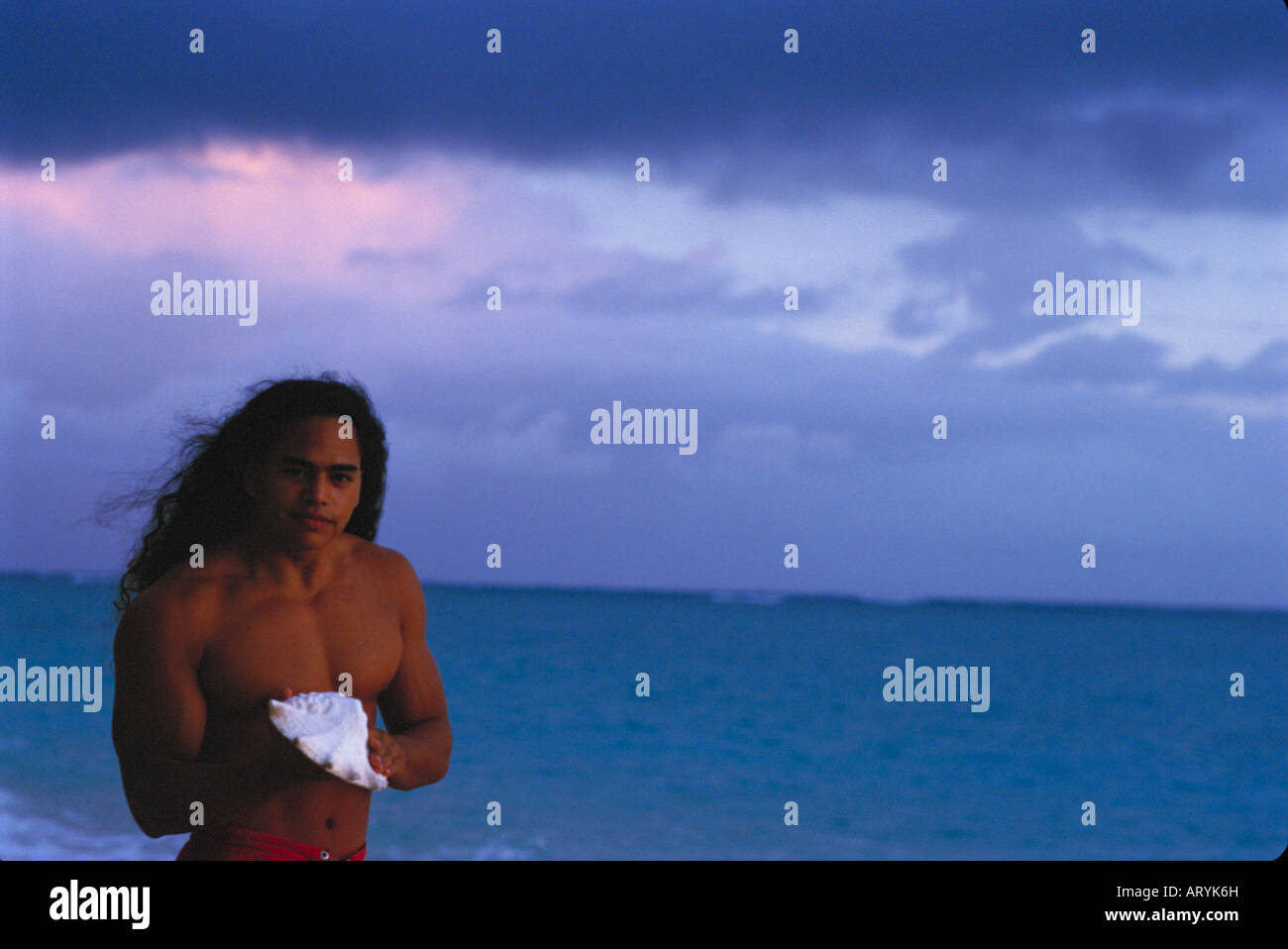 Young Hawaiian man at sunrise with conch shell Stock Photo - Alamy