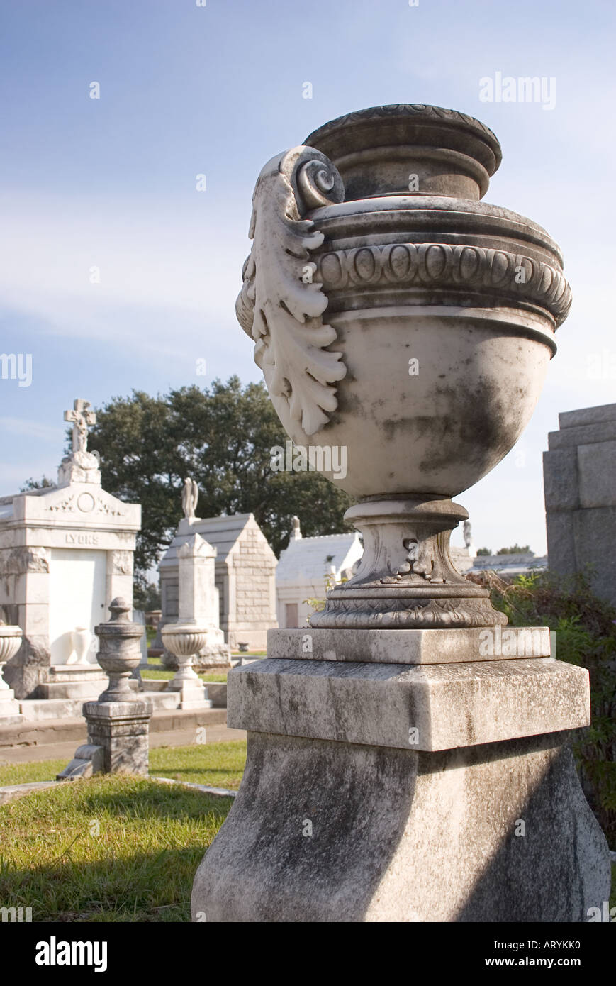 A marble urn in Metairie Cemetery faces a row of aboveground tombs. New Orleans, Louisiana, USA