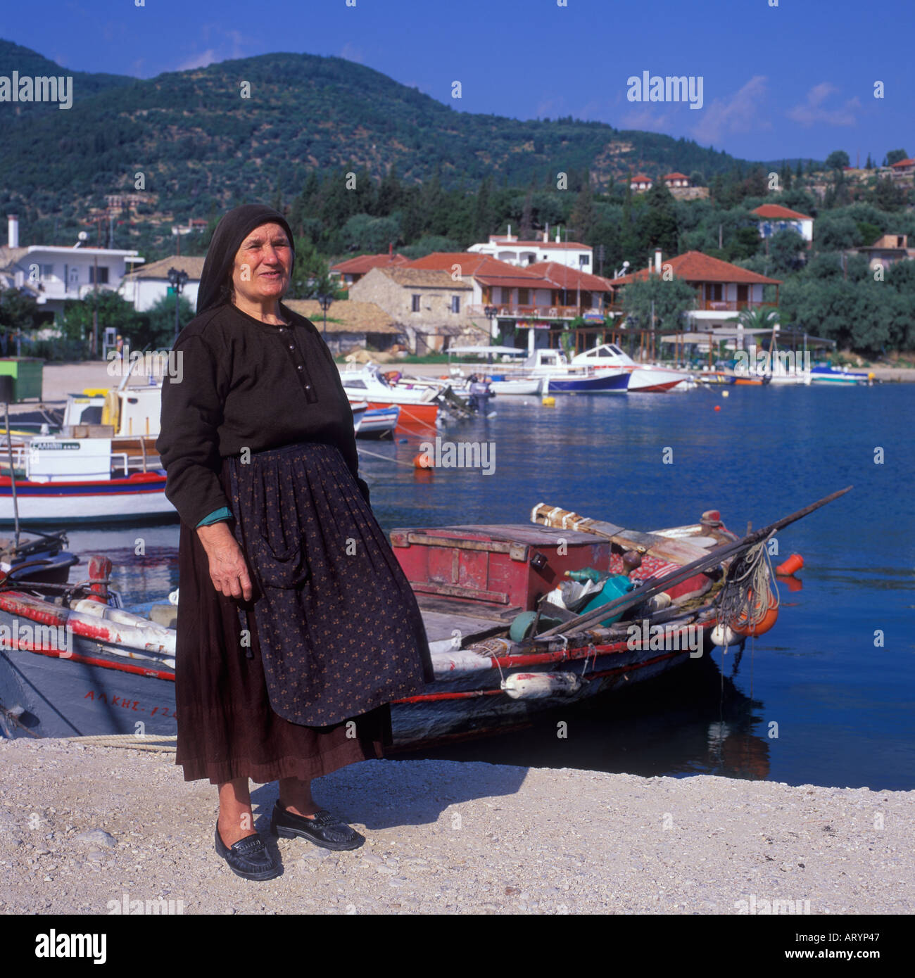 LOCAL WOMAN STANDING BY HARBOUR LEFKAS GREECE Stock Photo