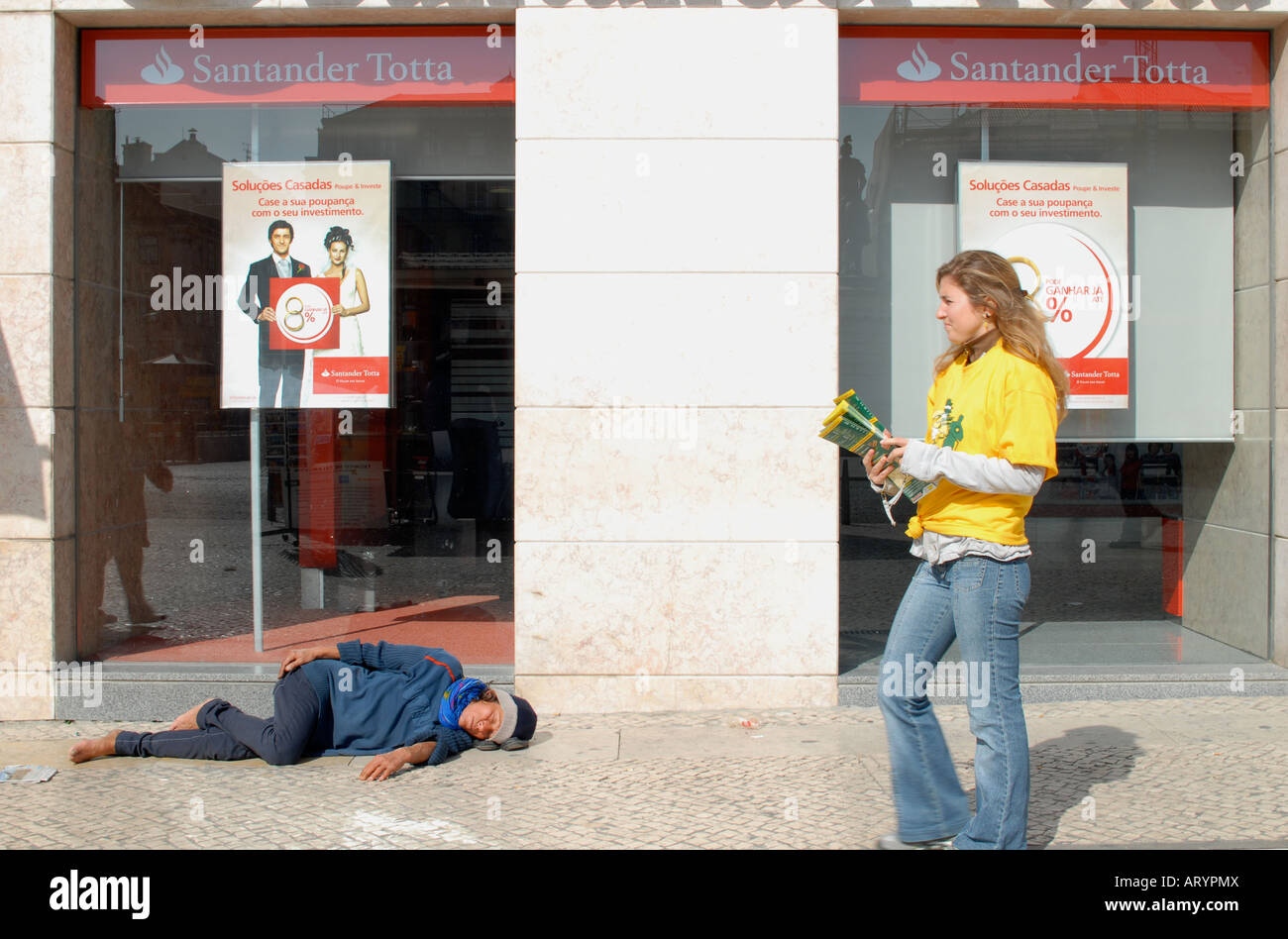 Sleeping rough outside a Santander bank with a pretty woman giving out fliers Stock Photo