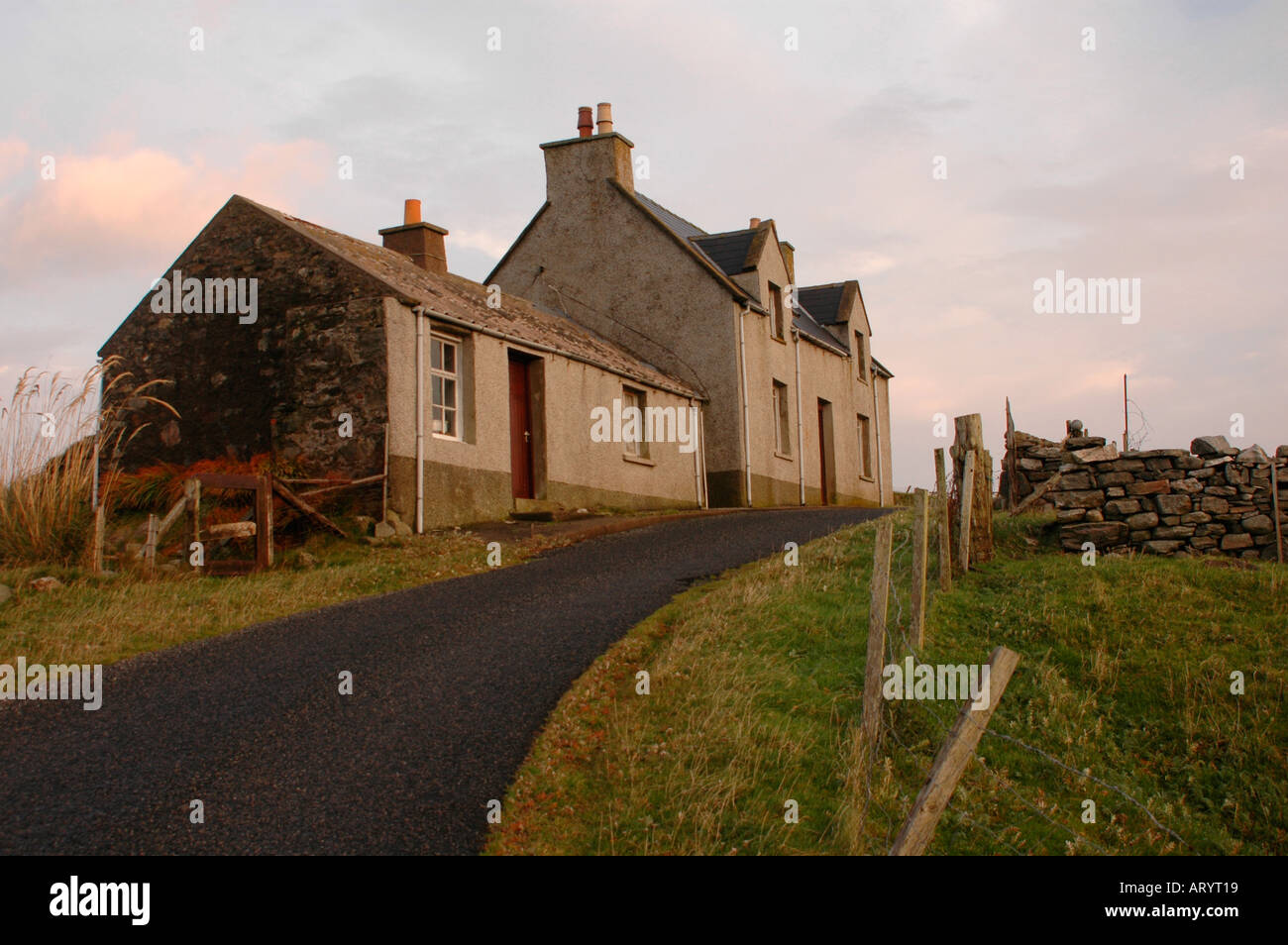 Grey, pebble-dash,  stone houses are typical of the north part of the Outer Hebrides Stock Photo