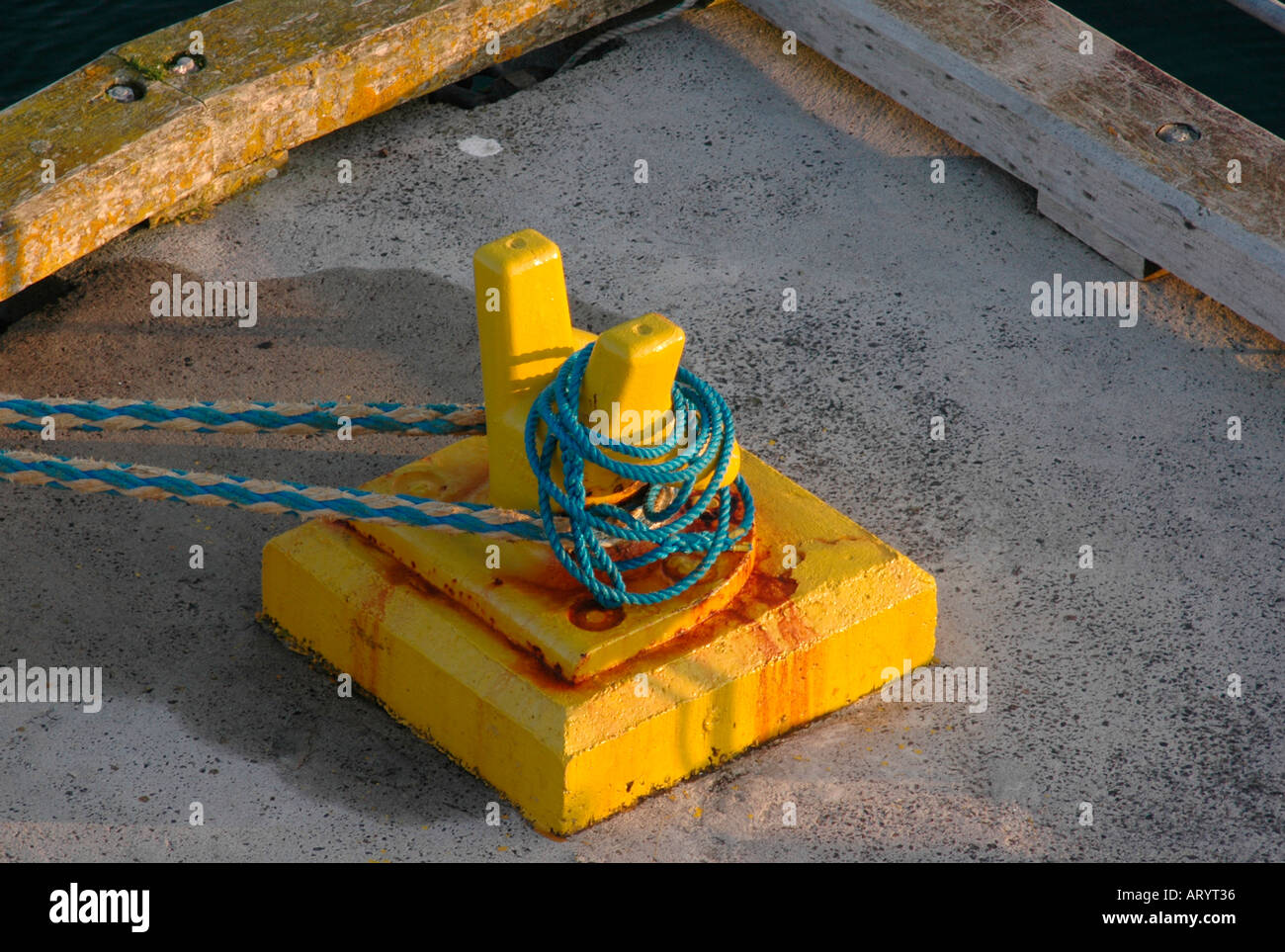 Yellow cleat with ropes on a concrete quay side Stock Photo Alamy