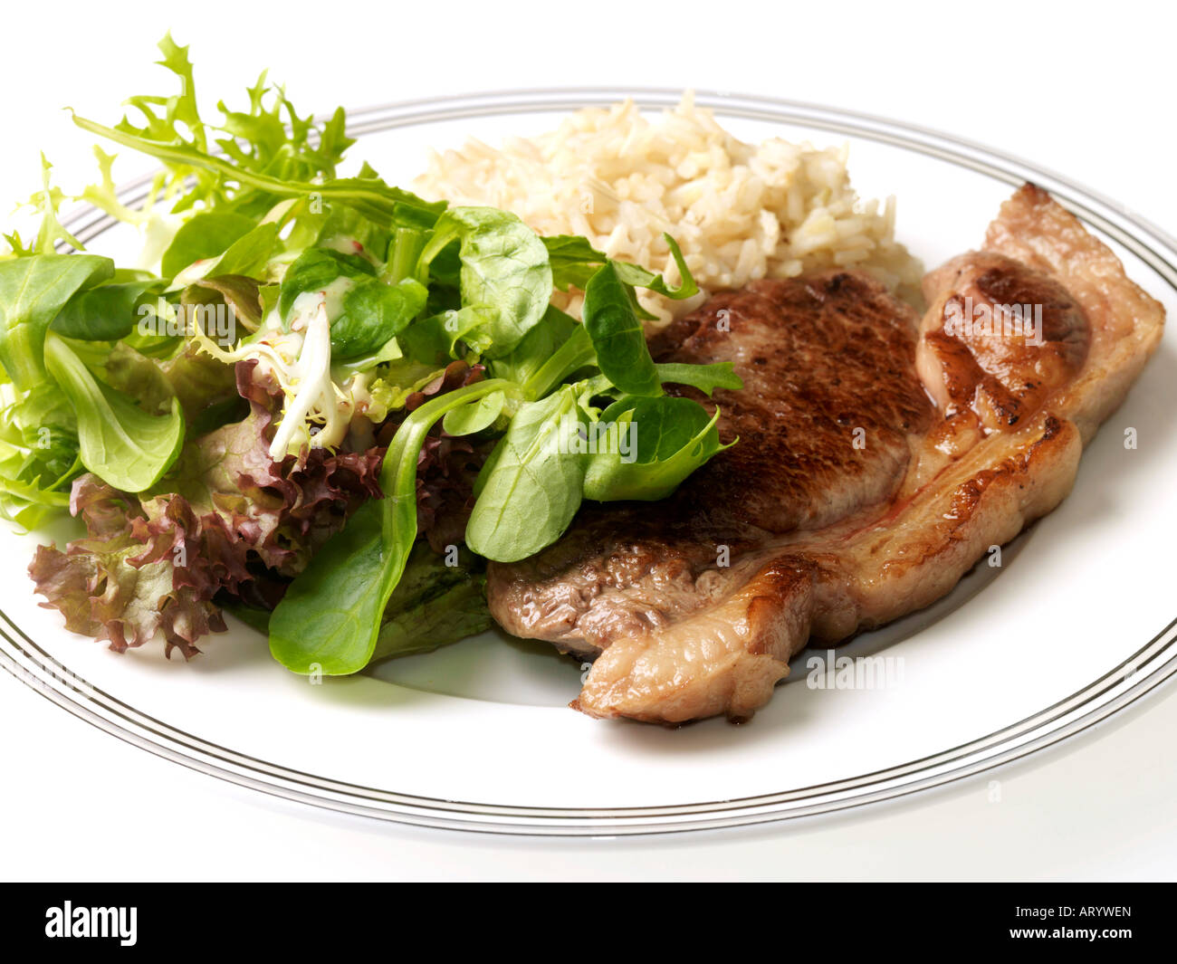 Fresh Lean Rump Beef Steak With Brown Rice and Salad Isolated Against A White Background With A Clipping Path And No People Stock Photo