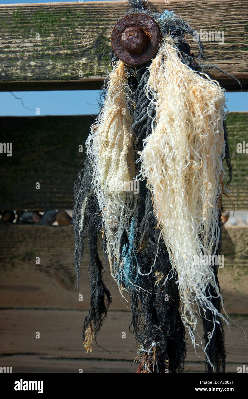Beach details frayed string hanging froma wooden breakwater Stock Photo ...