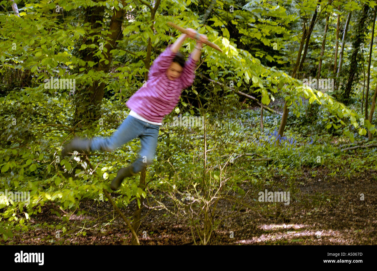 girl swinging through the trees Stock Photo Alamy