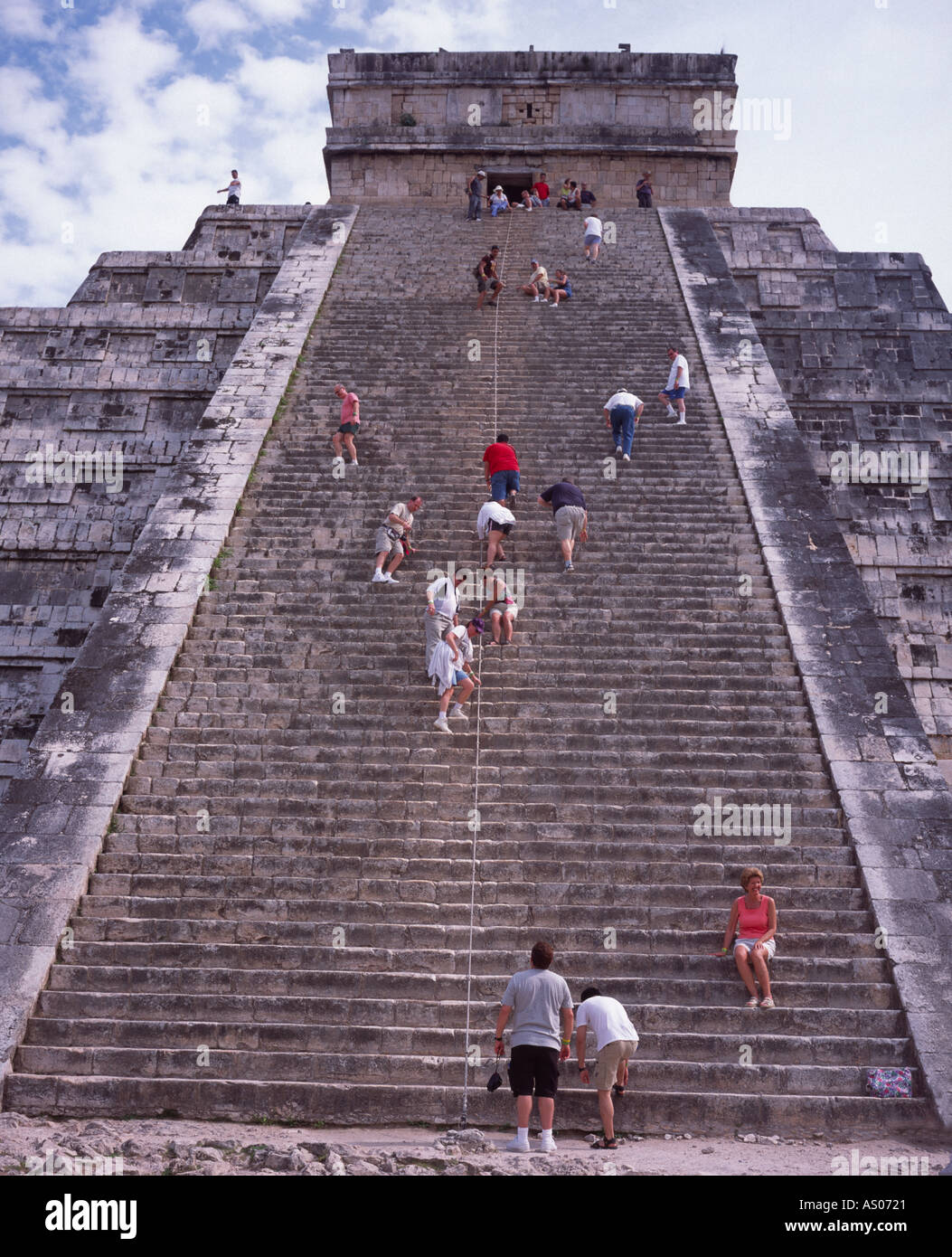 Tourists climbing the steep steps of the pyramid El Castillo Chichen